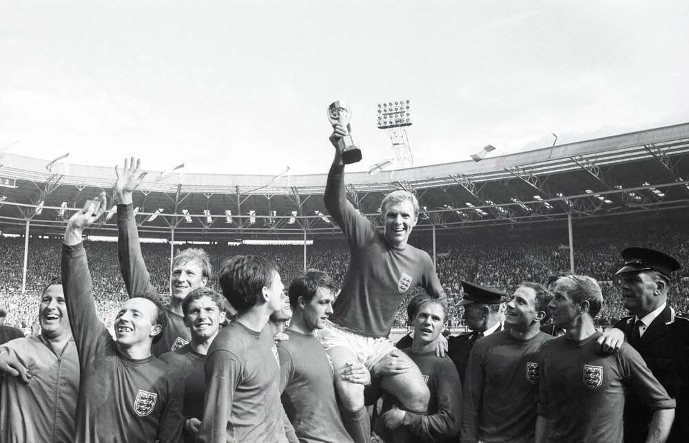 In one of perhaps the most famous World Cup images, England captain Bobby Moore proudly lifts the recently lost-and-found Jules Rismet Trophy in 1966.