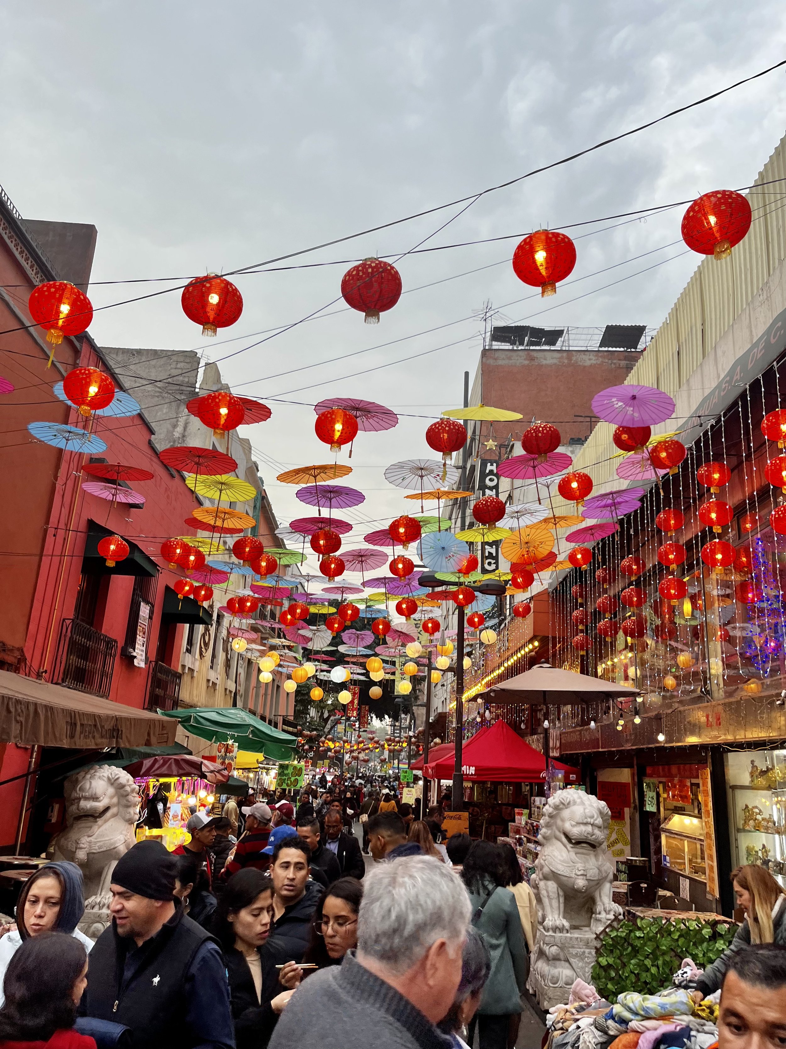 Chinese lanterns dangle overhead the crowd.
