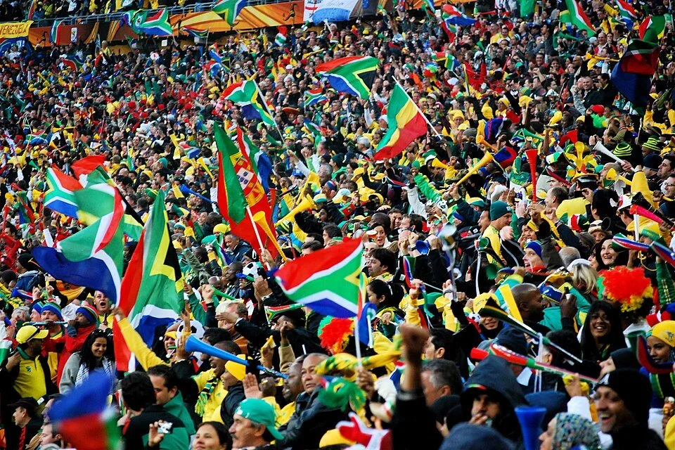 South African flags wave and vuvuzelas blow during the 2010 World Cup.
