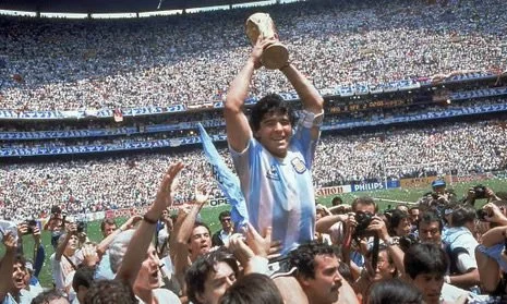 Diego Maradona uses two hands to raise the trophy, after knocking out England with his "Hand of God" goal in the quarterfinal.