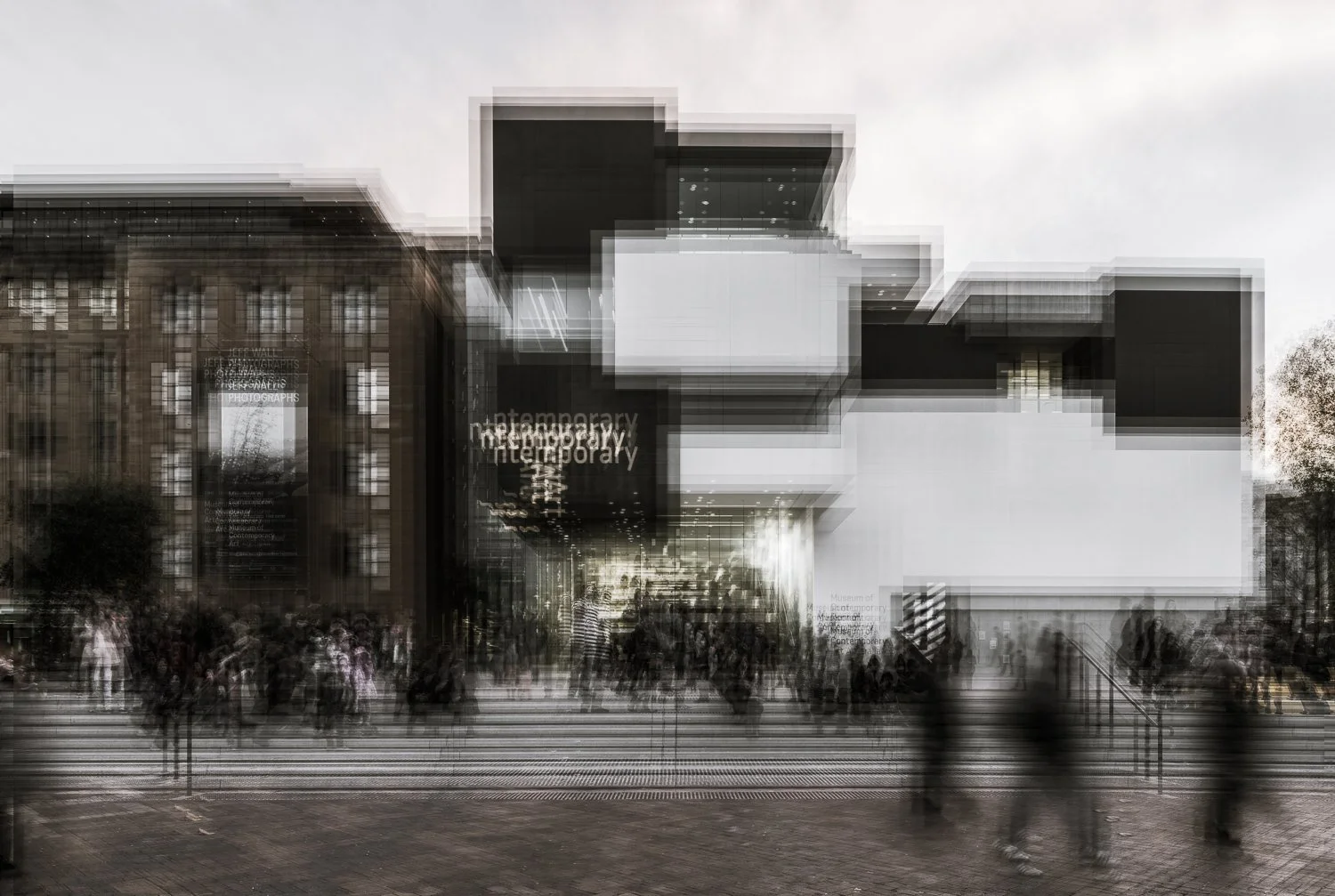 Blurred modern building with gallery signs and people walking outside.
