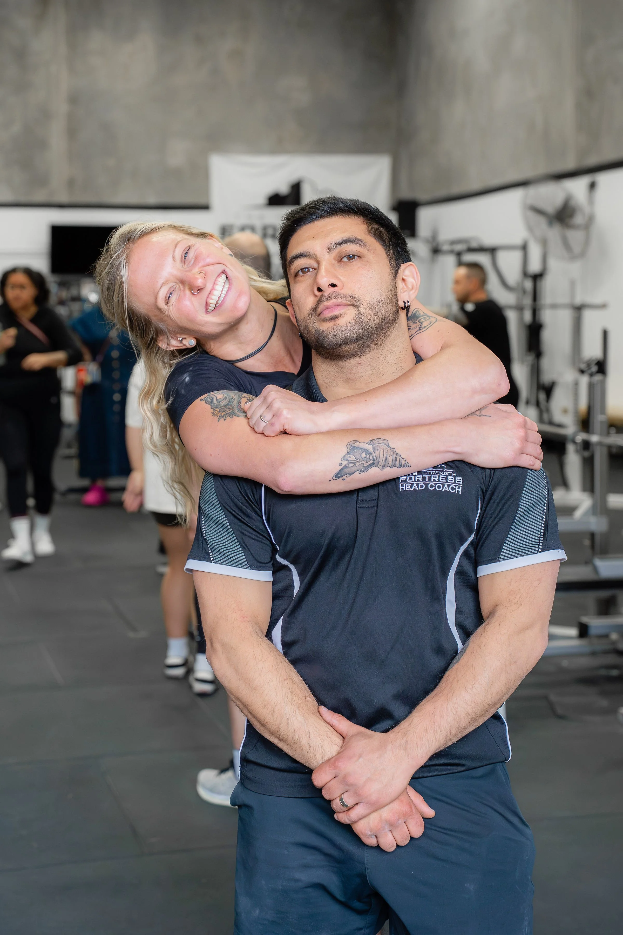 Barbell Club coaches, Billie and JP hugging each other
