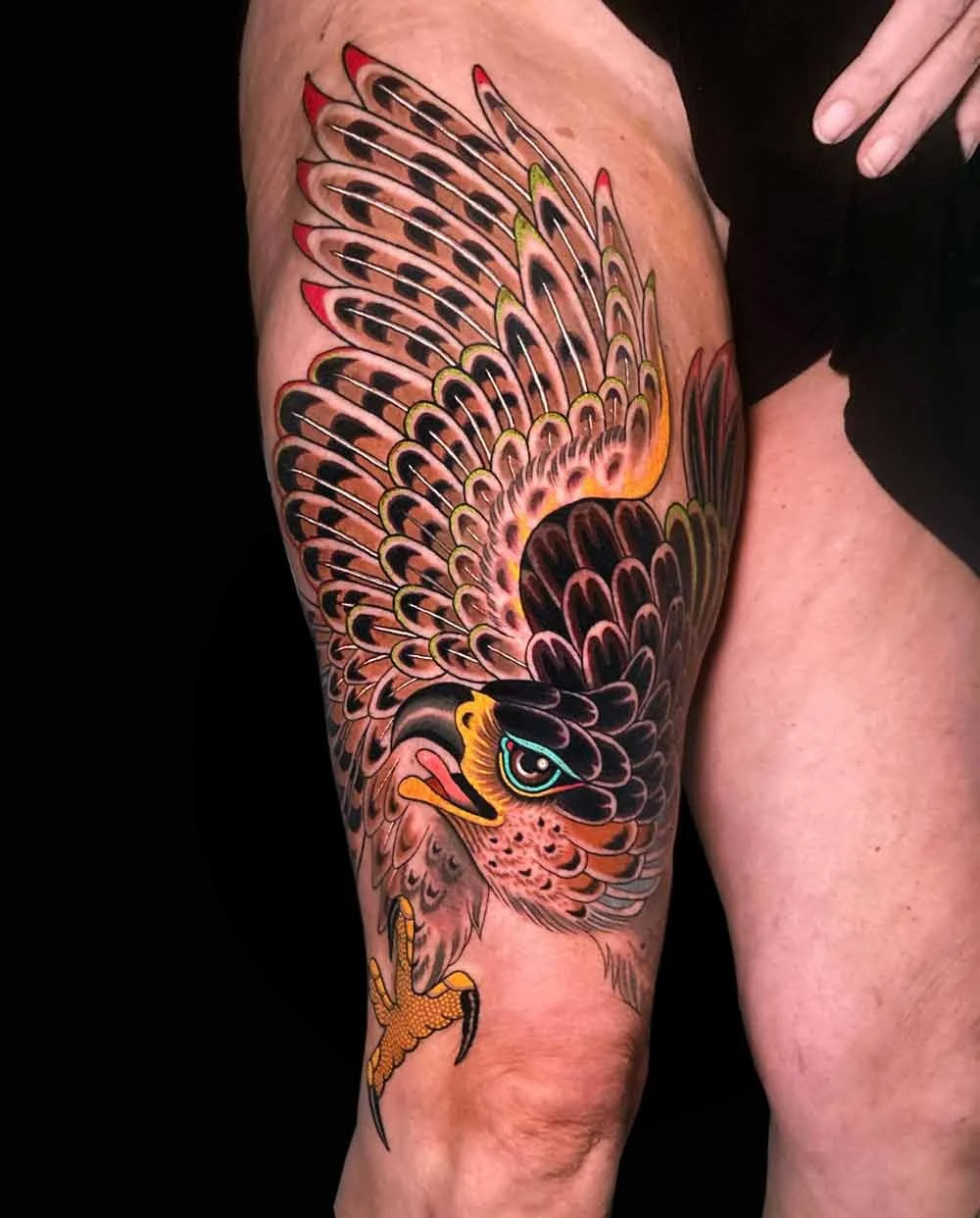 Bright, bold and delicate neotraditional realistic colourful tattoo of an eagle on a woman's thigh