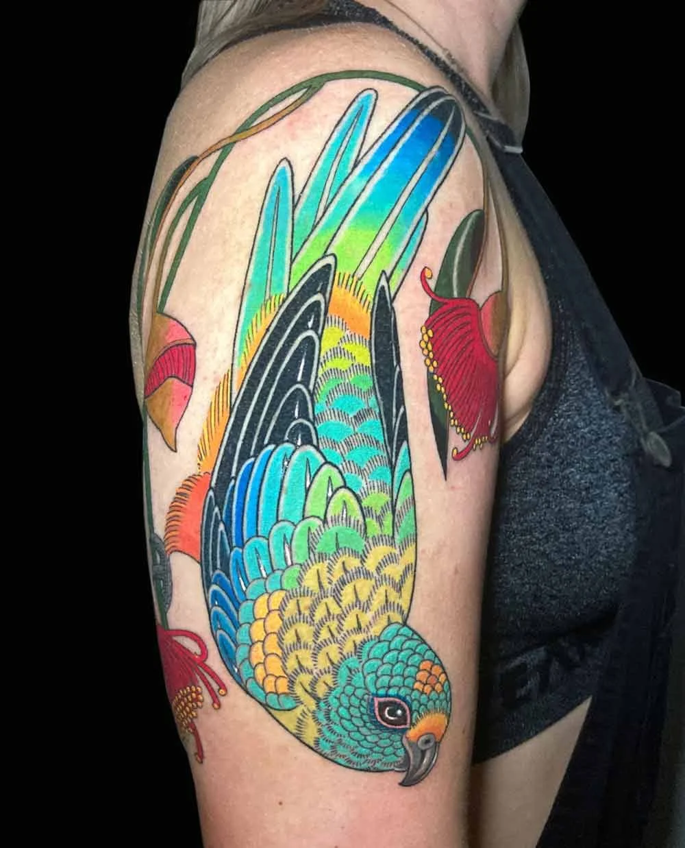 Bright bold delicate neotraditional realistic colourful tattoo of a mulga parrot austalian native bird on a womans arm 
