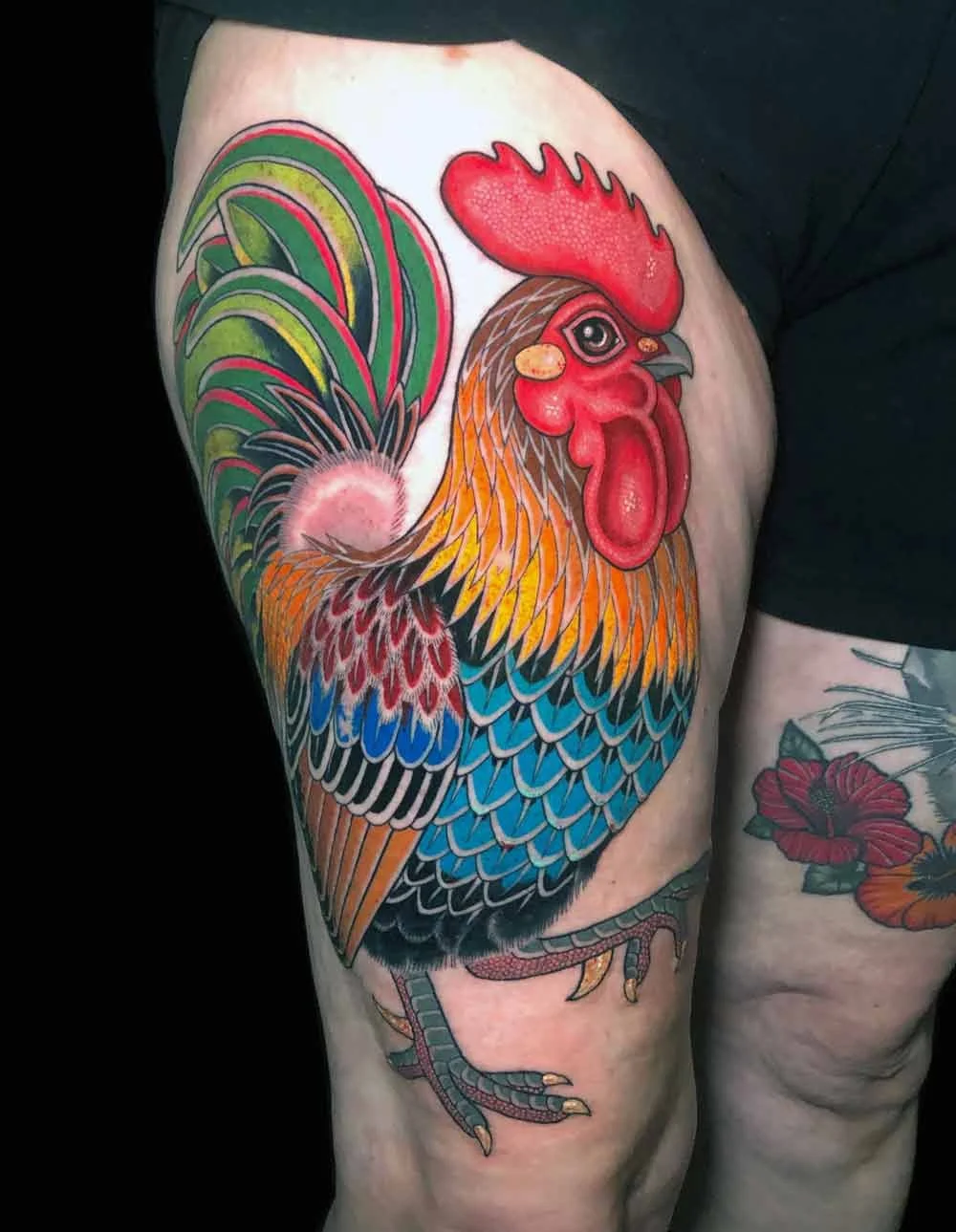 Neo traditional colourful realistic tattoo of a rosster on a woman's thigh