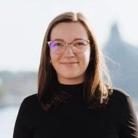 Portrait of Justīne Elferte, former Head of the International Department at the Riga Graduate School of Law, commending Tomasz Kramer’s open communication and critical insights in international capacity-building projects.