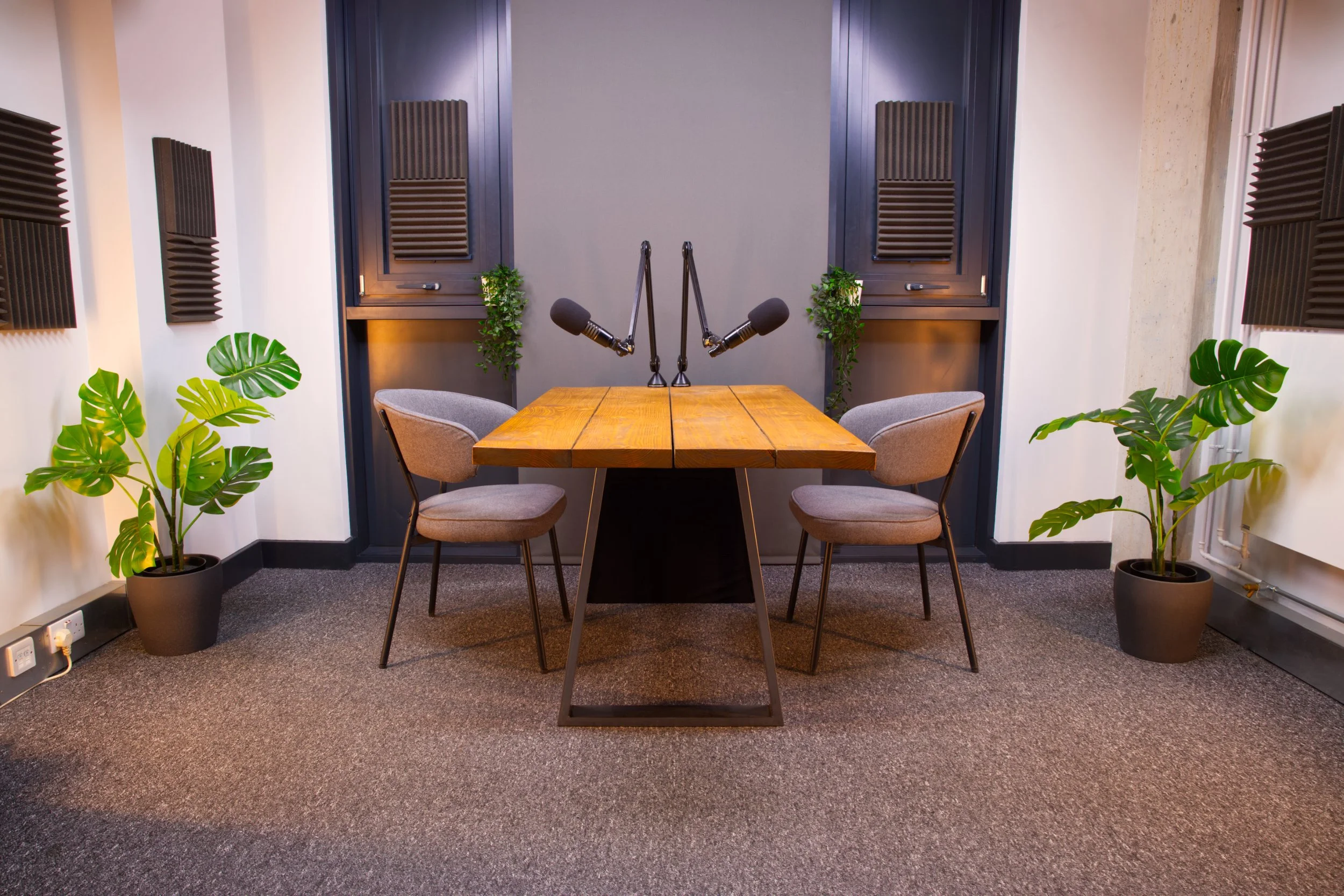 Table podcast set at Podcast Studio Hire in London, with a wooden table, professional microphones and acoustic treatment.