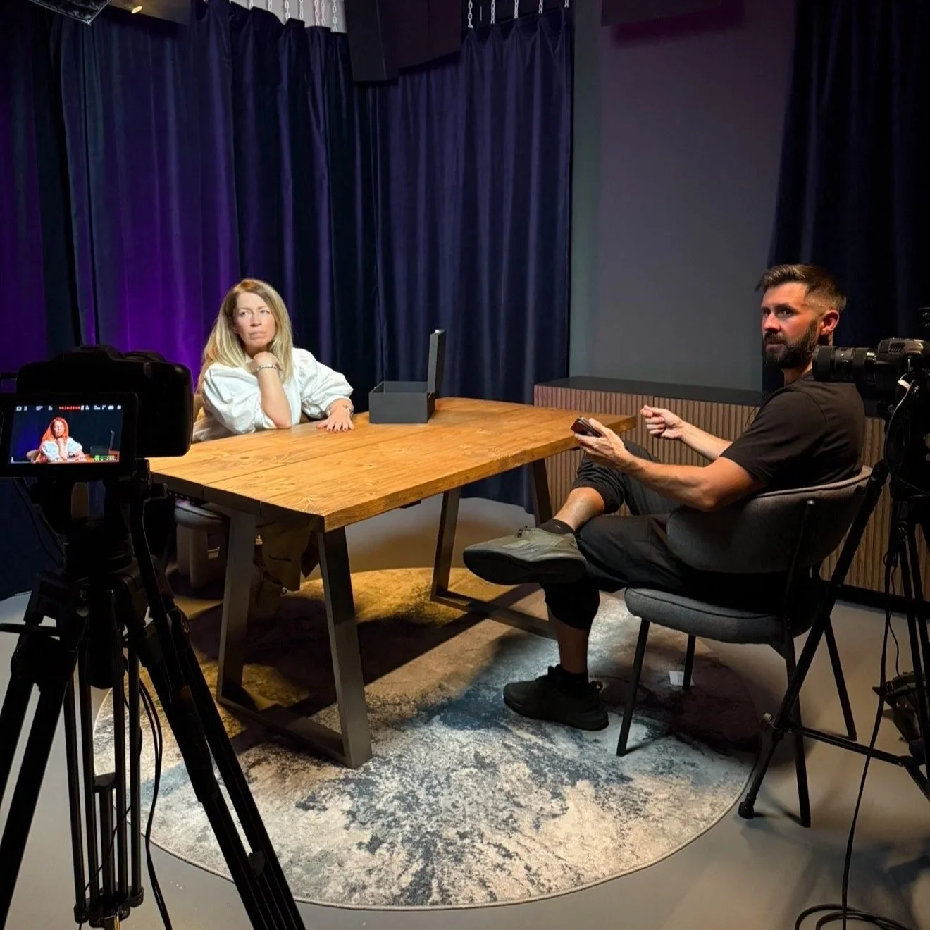On-location podcast recording setup with cameras at a London venue