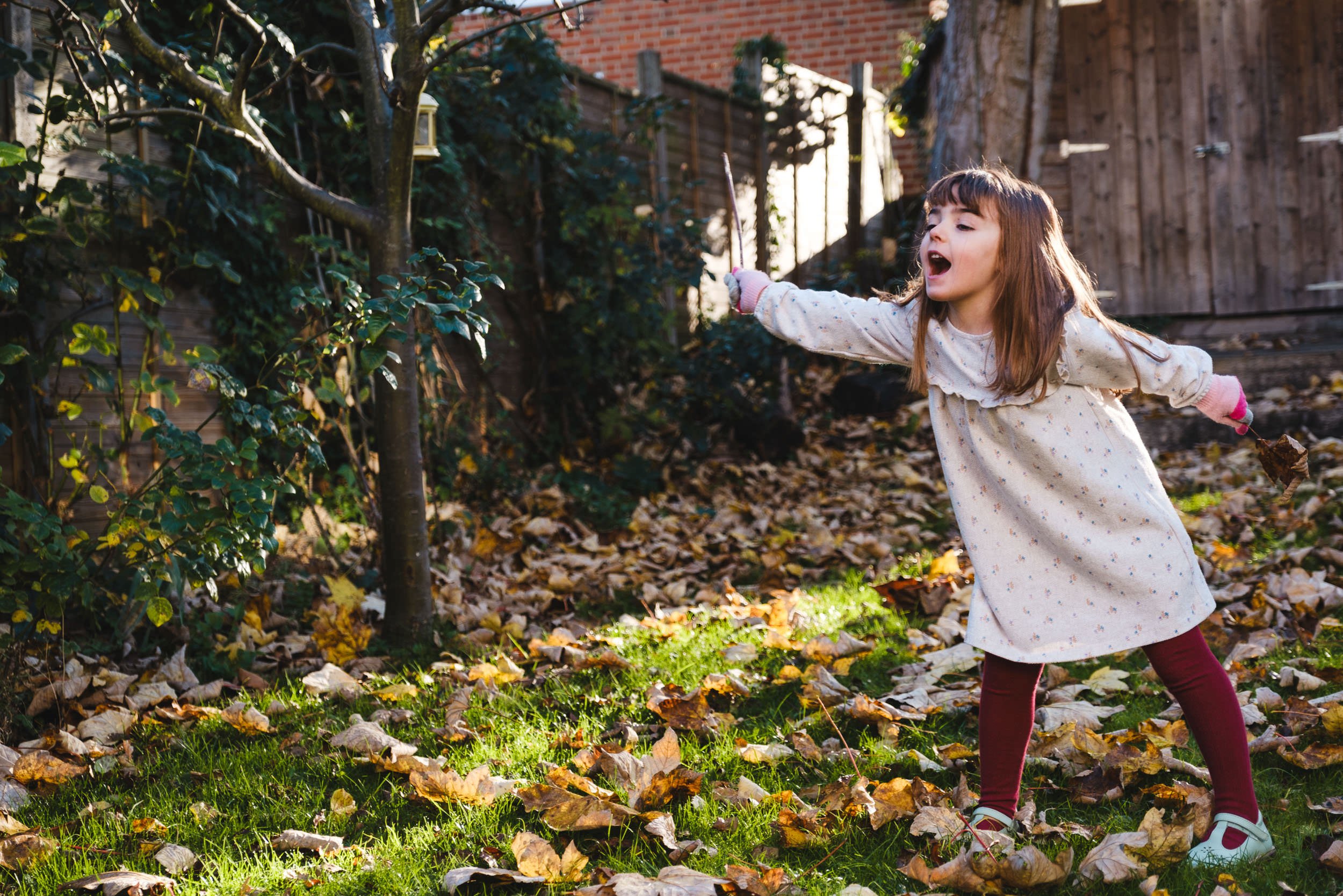A girl playing in the leaves