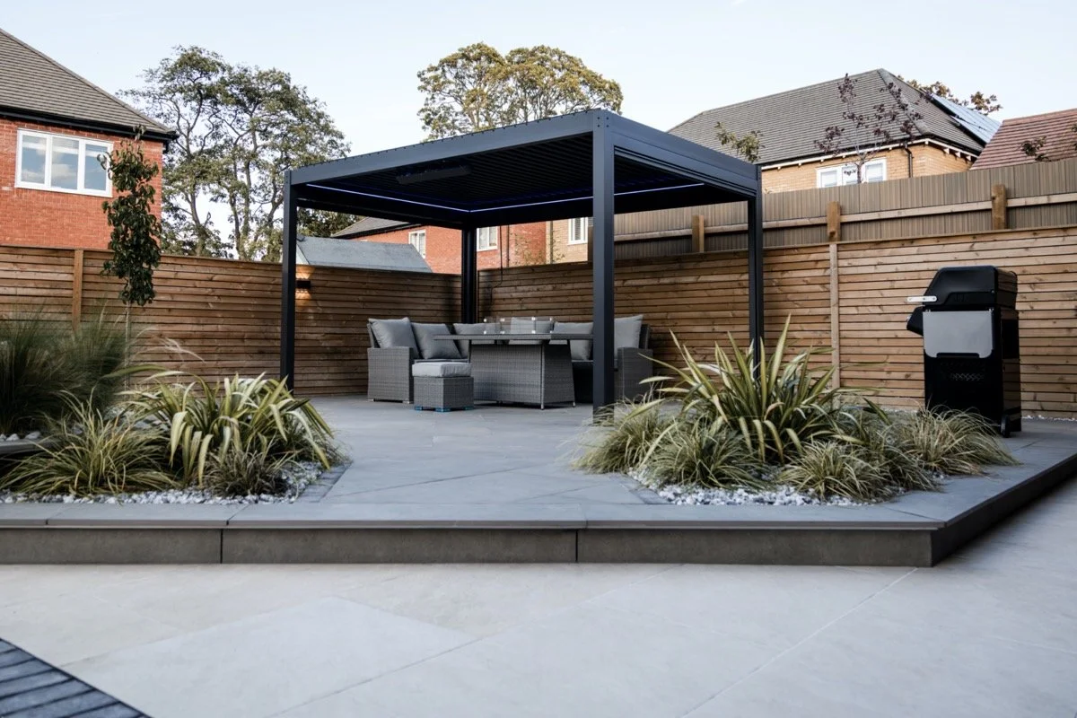 Contemporary garden transformation featuring a modern pergola, premium paving and landscaped seating area.
