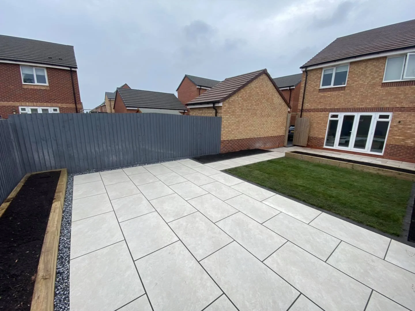 white patio slabs and new lawn