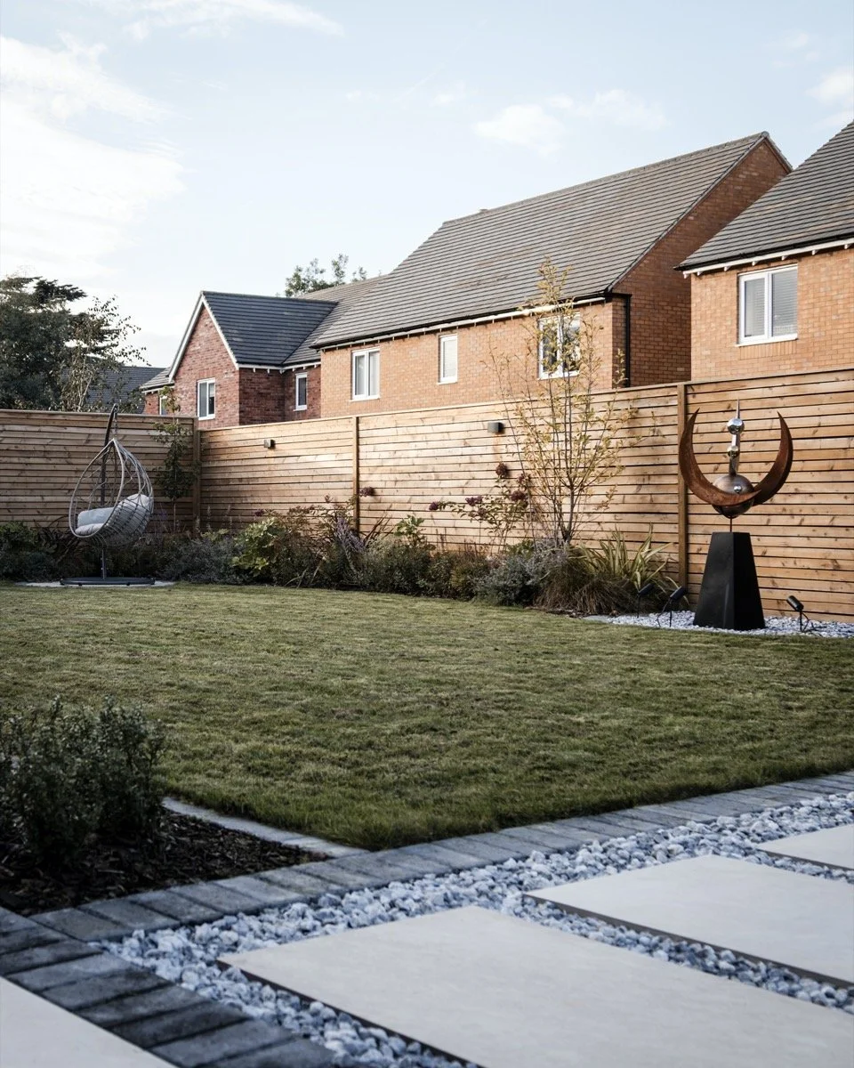 Beautifully landscaped garden featuring contemporary timber fencing, ornamental planting and a statement sculpture.