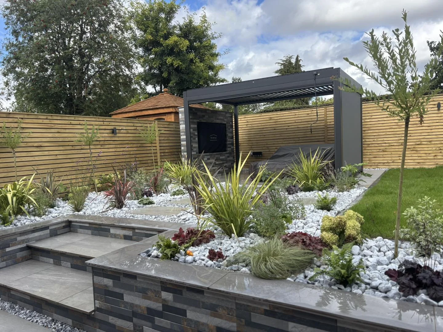 Allergy-friendly garden with raised beds and paving in Stafford
