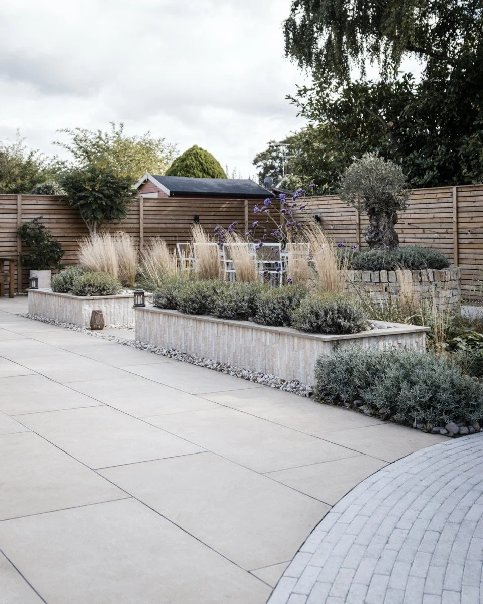 Contemporary garden in Elford with porcelain paving, raised planters and elegant outdoor living space.