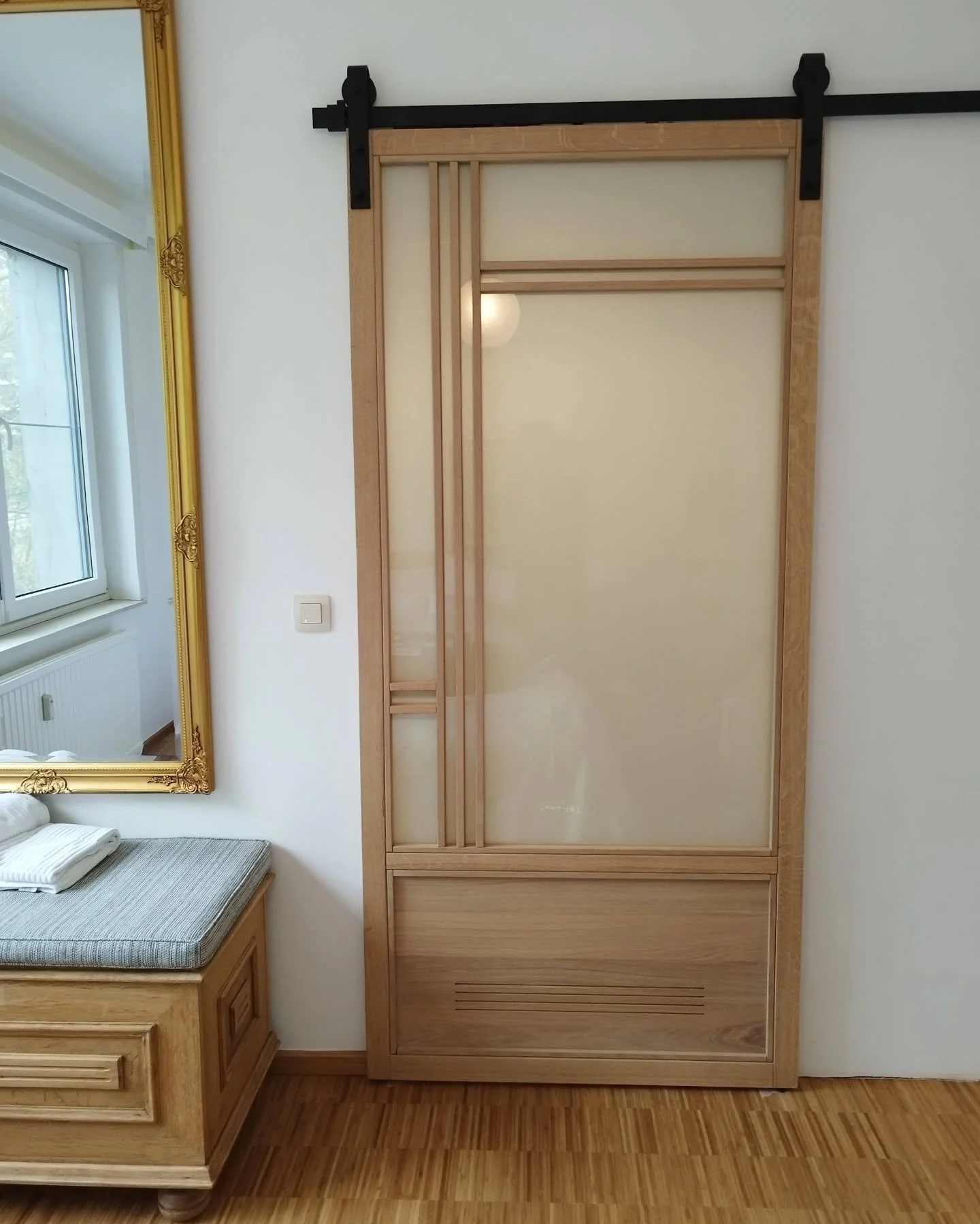 A custom-made Japanese-style inspired design sliding door installed to separate the bathroom from the master bedroom.

A perfect match with the atmosphere of the room and its wooden floor. 

The opaque glass door provides a soft atmosphere to the roo