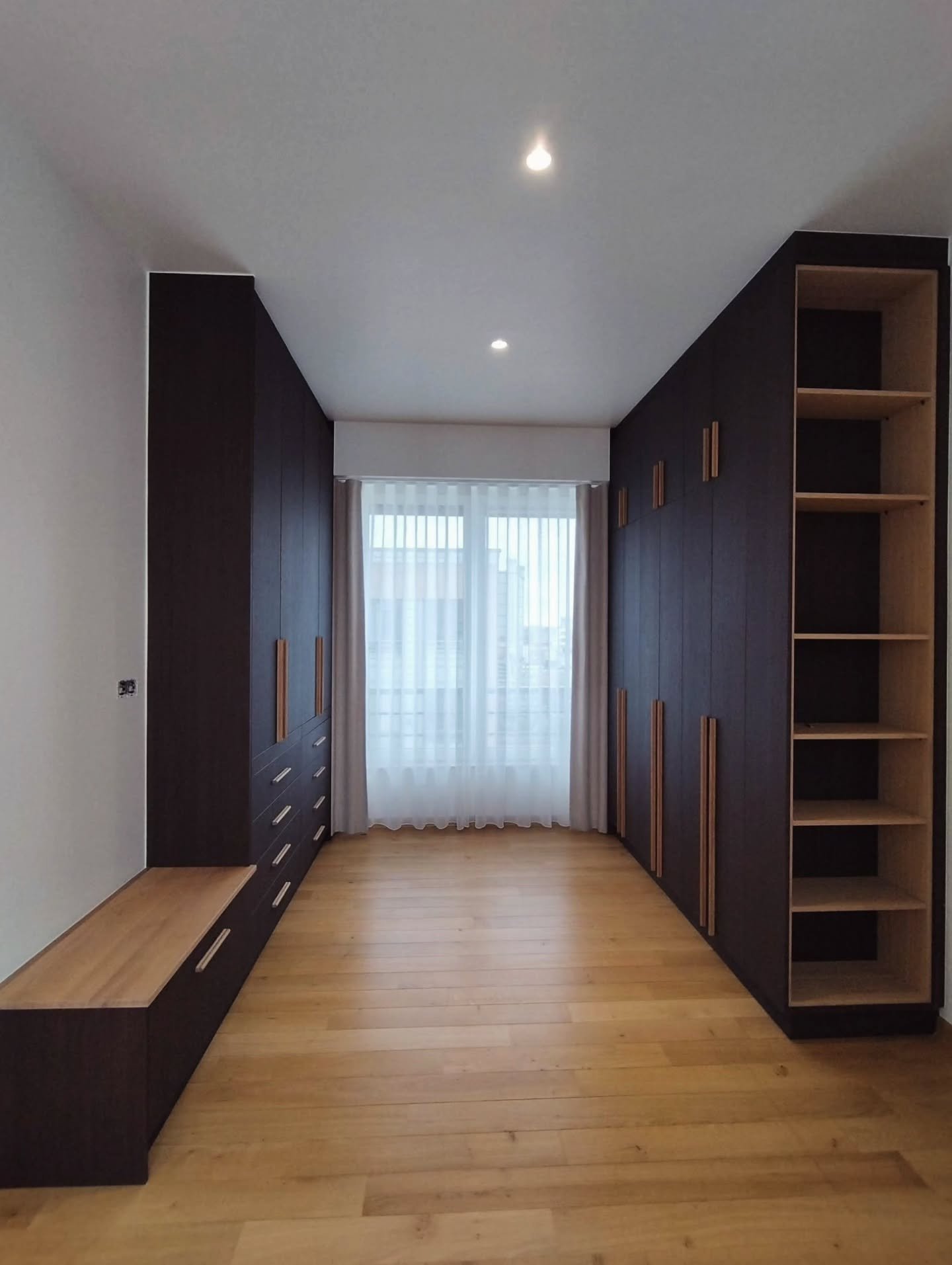 In-suite dressing &ndash; master bedroom

An astonishing cabinet project in a luxury apartment in the centre of Brussels.

The design features two full walls of custom cabinets. 

One side is mainly dedicated to hanging clothes and also includes a li