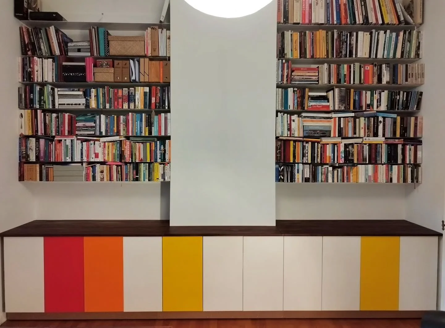 Awesome built-in cabinet of 4,5m long underneath a hanging library in a beautifull Beaux-Arts style appartment in the Brugmann district of Ixelles. 

The design offers a large amount of storage capacity while providing a vibrant look at the space tha