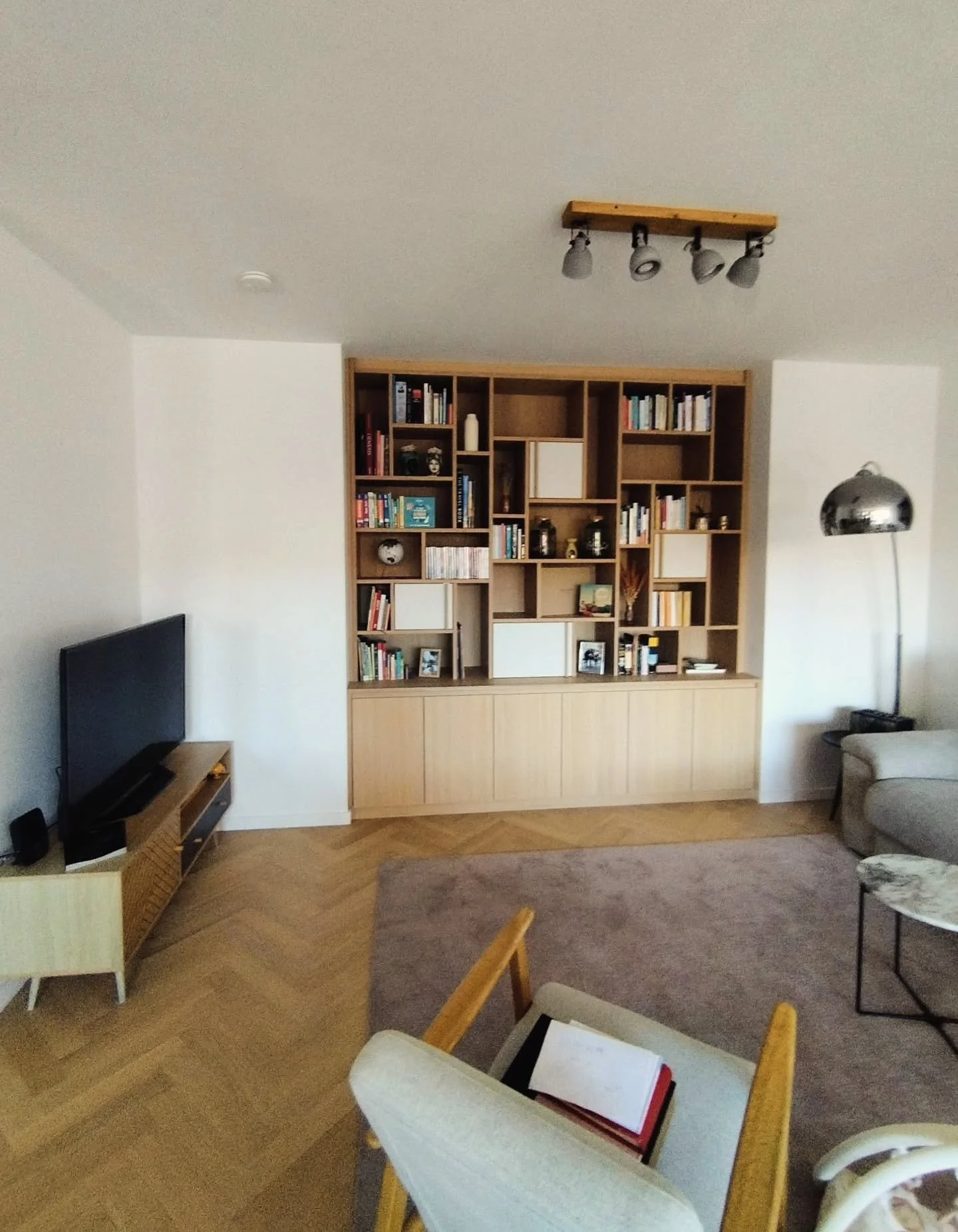 Modern asymmetric library in oak wood.

Custom-made furniture designed for an open niche in a living room of a renovated apartment in Ixelles.

The asymmetric open compartments, combined with a few closed sections, create a timeless and balanced desi