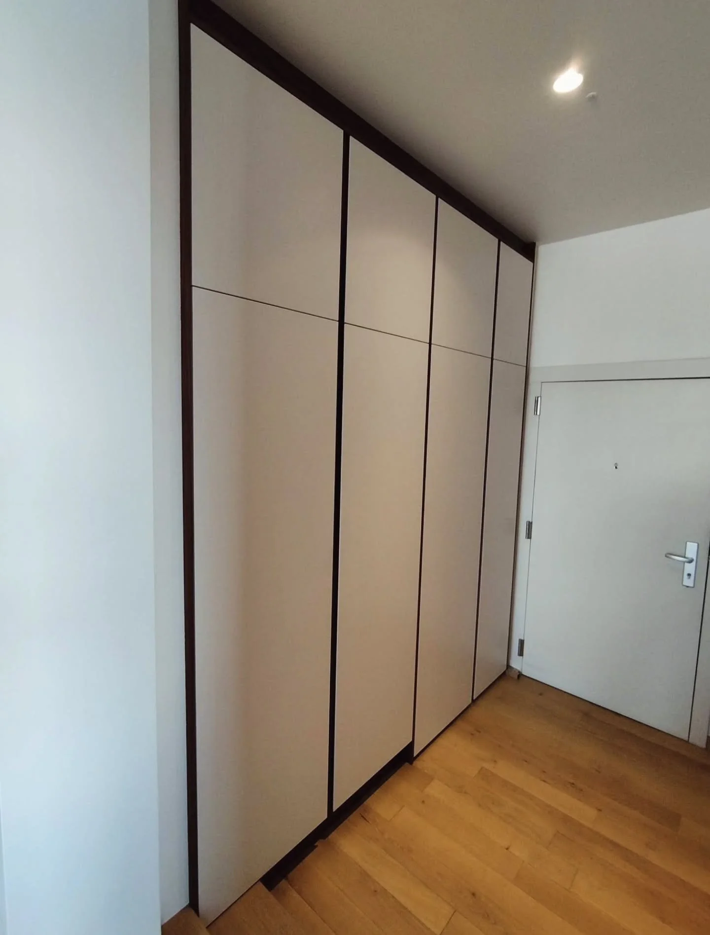Custom-made cloakroom cabinet.

Minimalist design with clean, straight lines and natural walnut milled handles. 

Designed as a refined and functional statement piece, this custom-made cloakroom cabinet creates a beautiful first impression upon enter