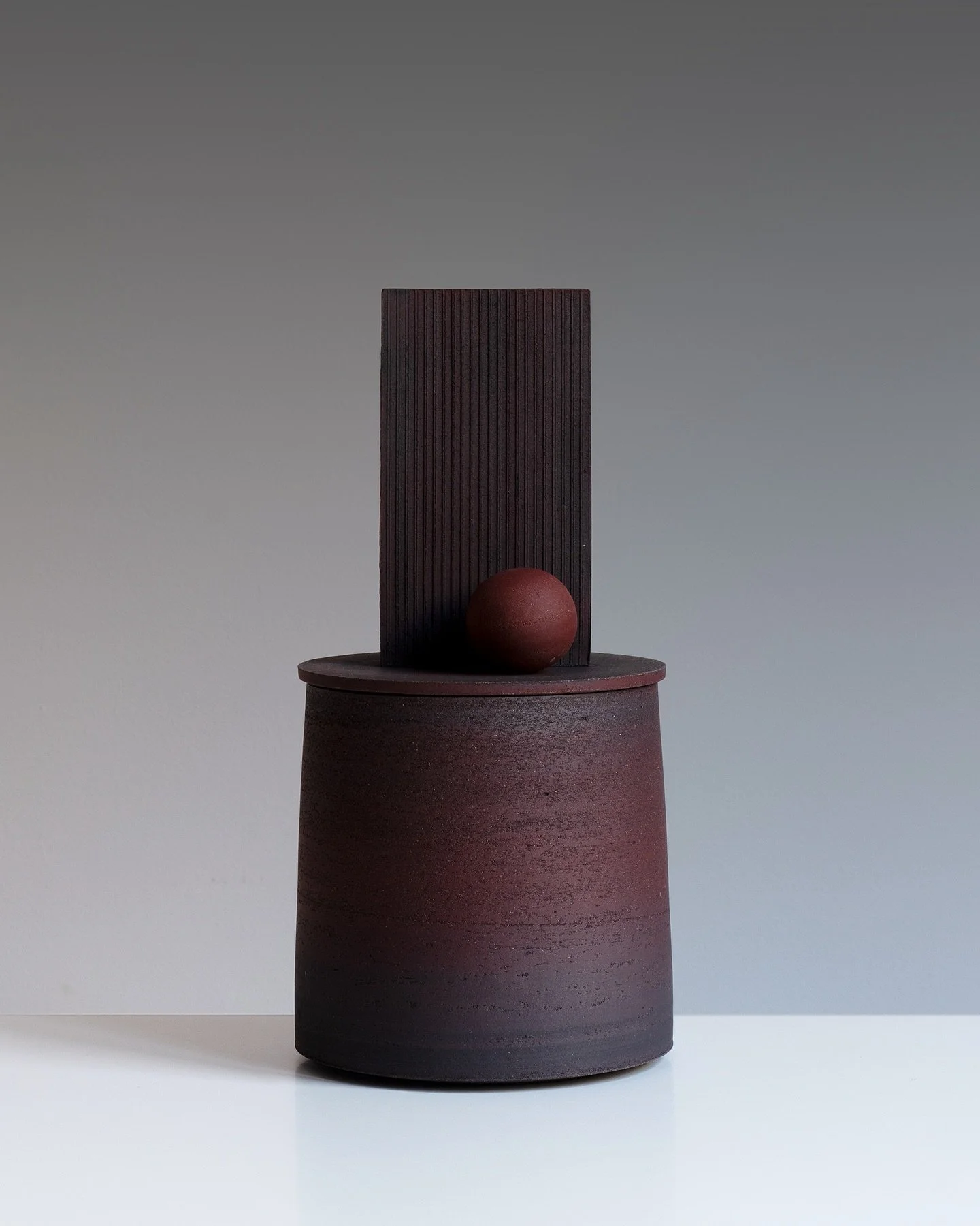 Sculptural Lidded Vessel with Stacked Planes and Sphere

I&rsquo;ve just finished building a small group of slab built forms which has been rather enjoyable. The pieces are now wrapped up in plastic and I will leave them alone for a while and they ca