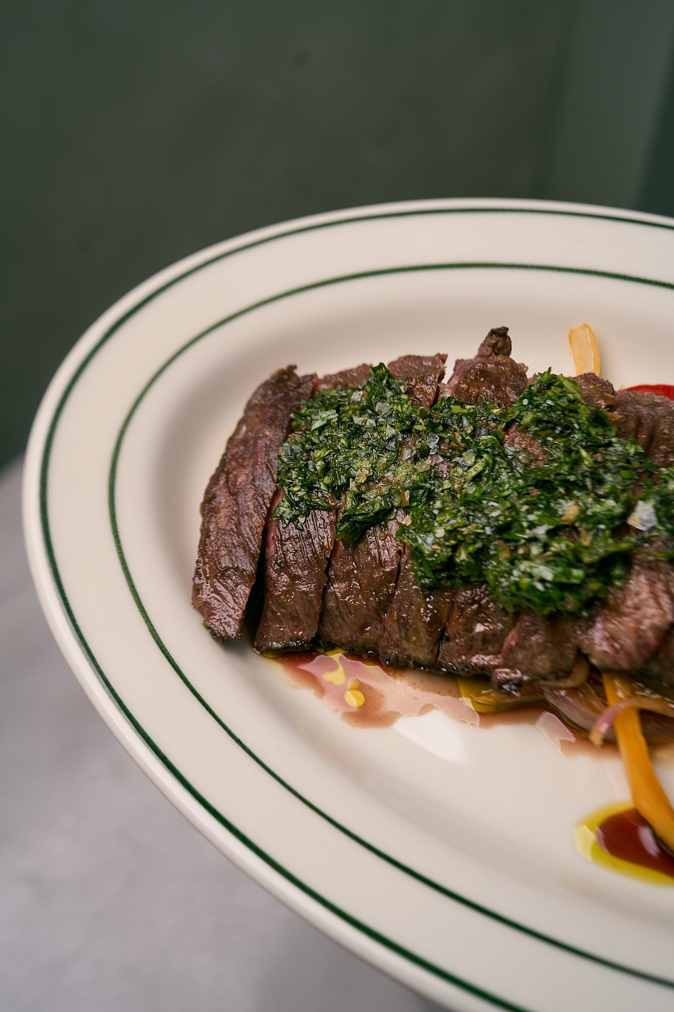 Skirt steak in a plate with fresh herbs on the top