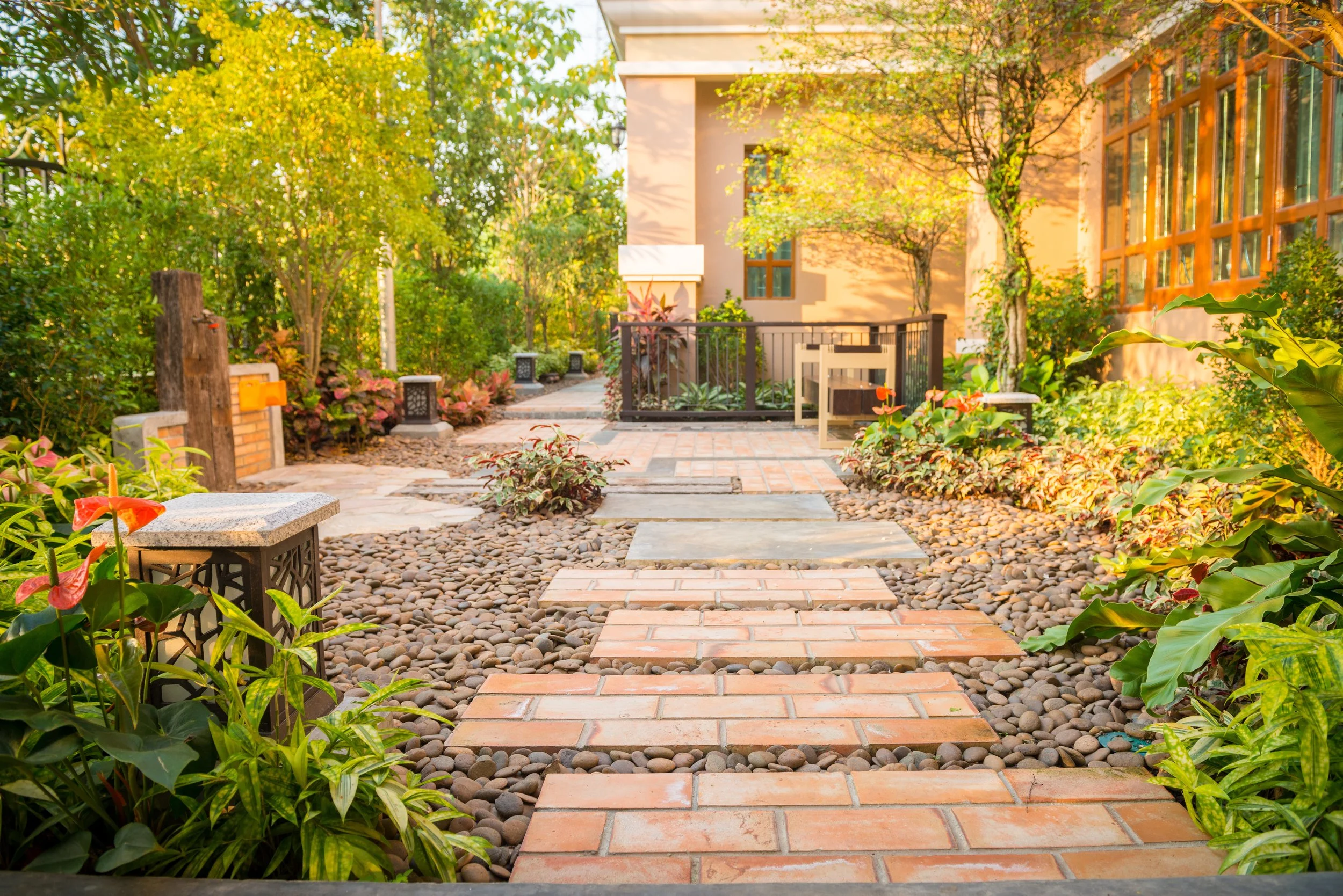 Minimalist commercial walkway with modern pavers set in stone gravel and natural landscaping designed to create a park-like entrance and improve curb appeal