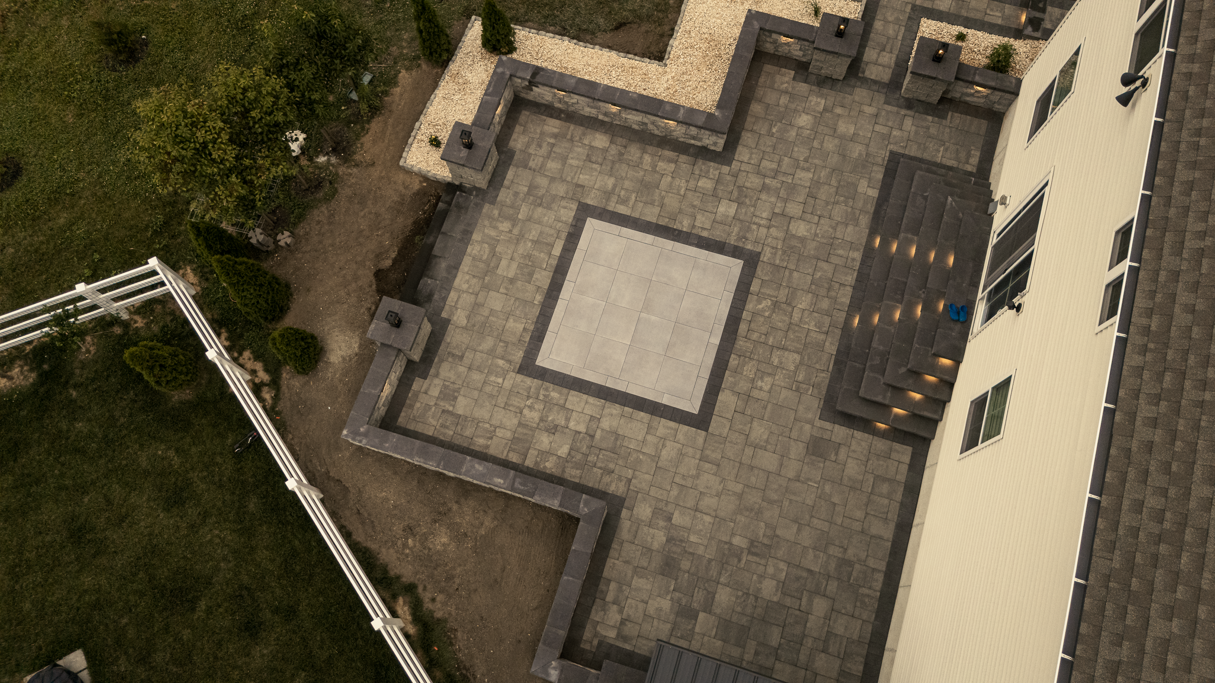 **Image Alt Text (SEO):**  **Studio G meeting with homeowners on a completed custom Belgard paver patio in Middletown, DE during a backyard design consultation.**