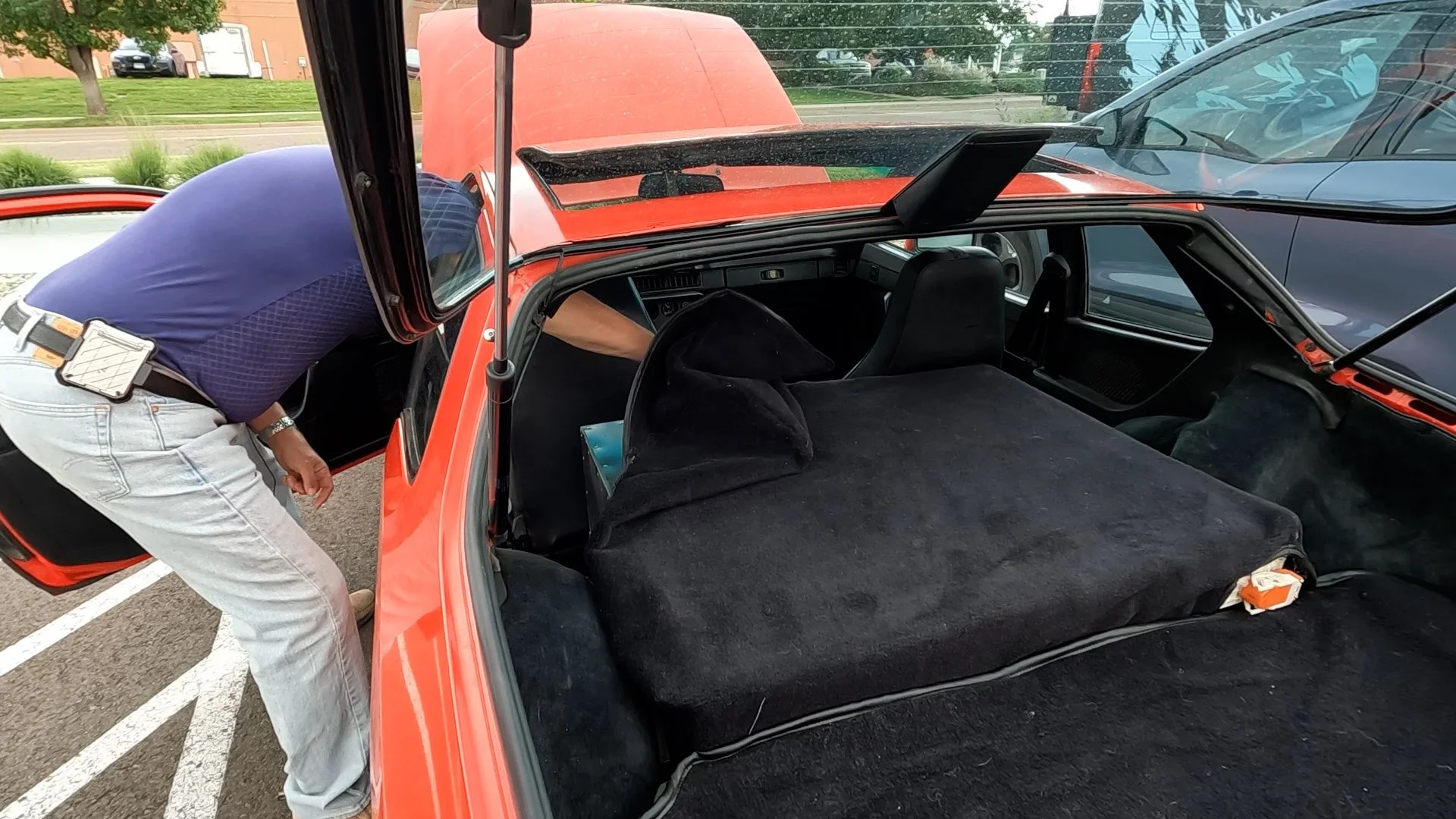 Porsche 924 back seat now holds batteries from a Nissan Leaf and is covered with carpet to look stock