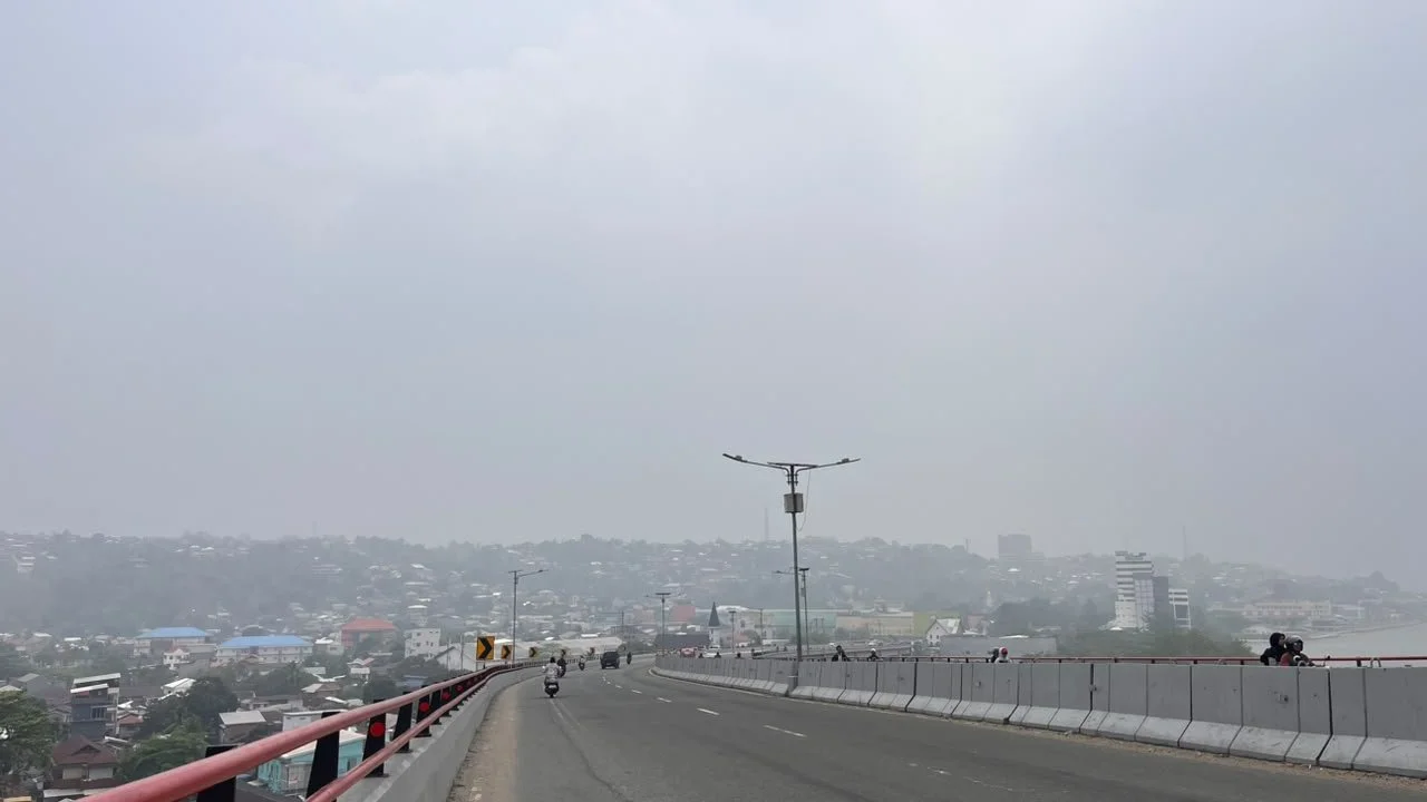 Ambon-stad gezien vanaf de Merah Putih-brug, nauwelijks zichtbaar door de rook