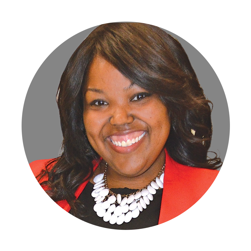 Smiling woman with dark hair, wearing a red blazer and white statement necklace