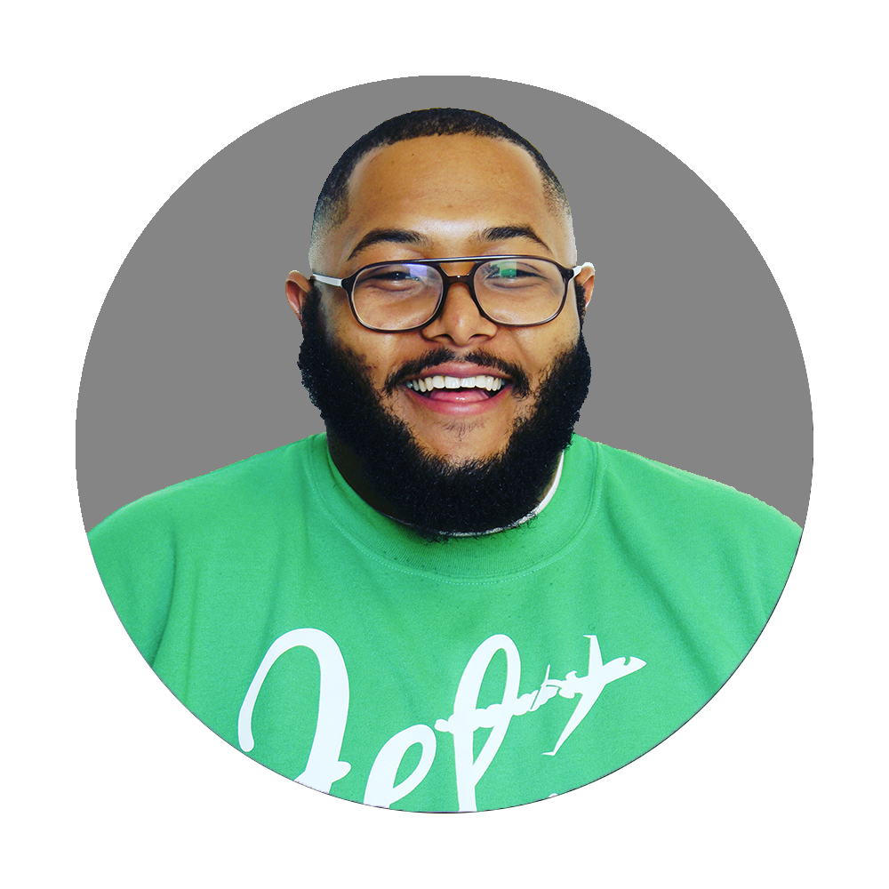 Smiling man with glasses and a beard wearing a green T-shirt.