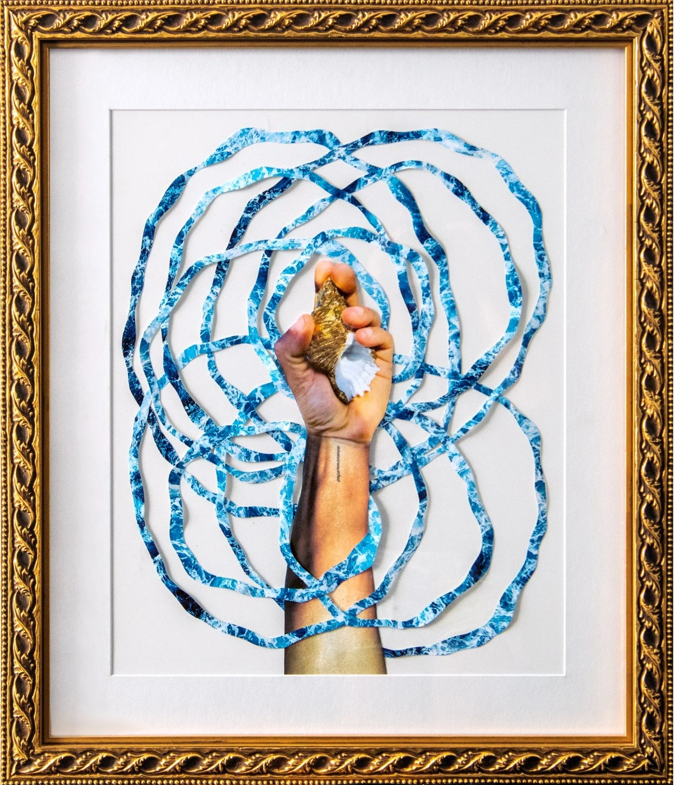 An ornate gold frame surrounds artwork featuring a human hand gripping a shell, with a picture of ocean water on the hand and wrist. Blue marbled paper strips swirl outward from the hand, creating a spiral pattern. by Fabio Borges