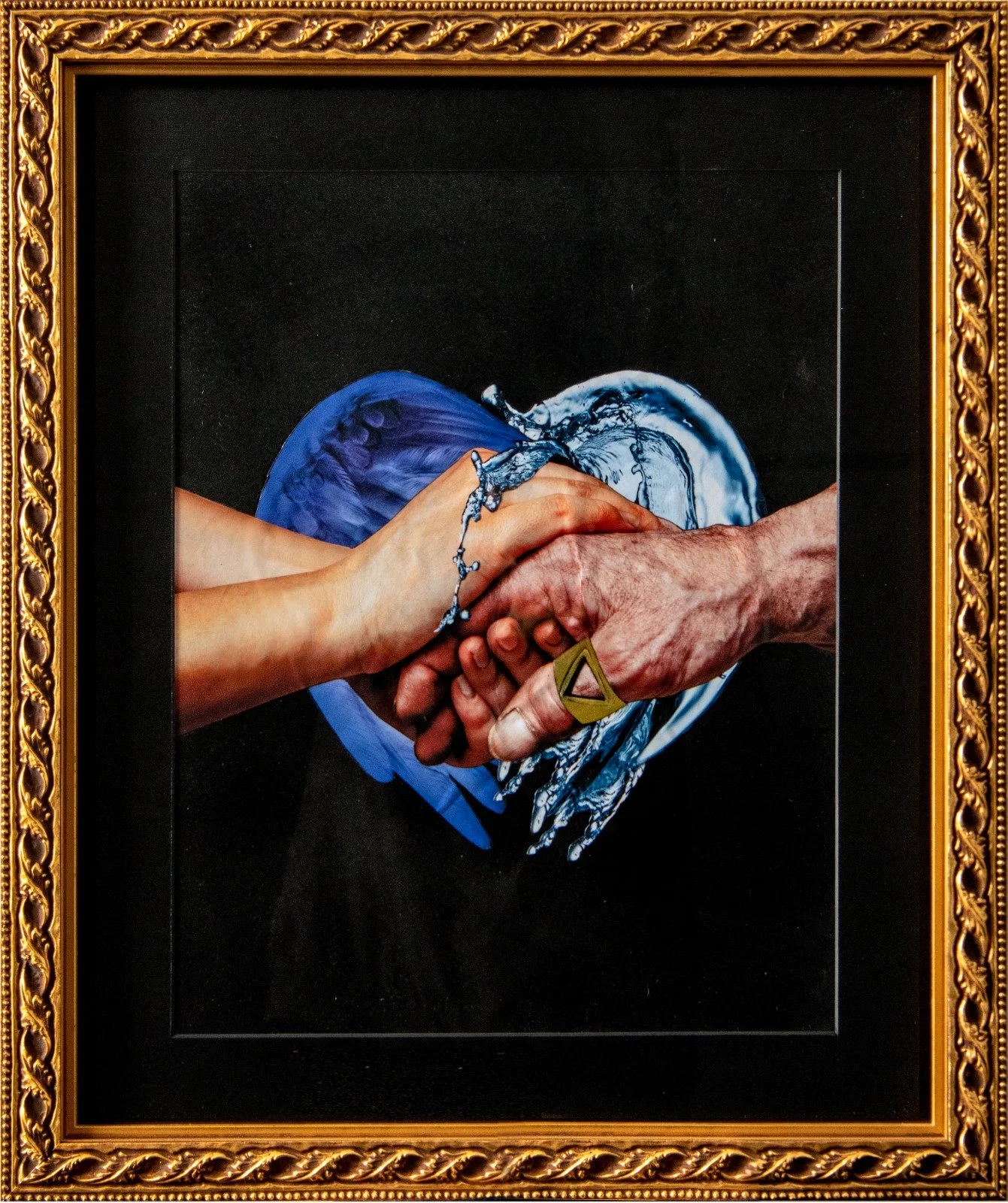 A framed painting of two hands clasped in a handshake inside a heart-shaped outline, with a background of blue and white water splashes. collage by Fabio Borges - Cura Series
