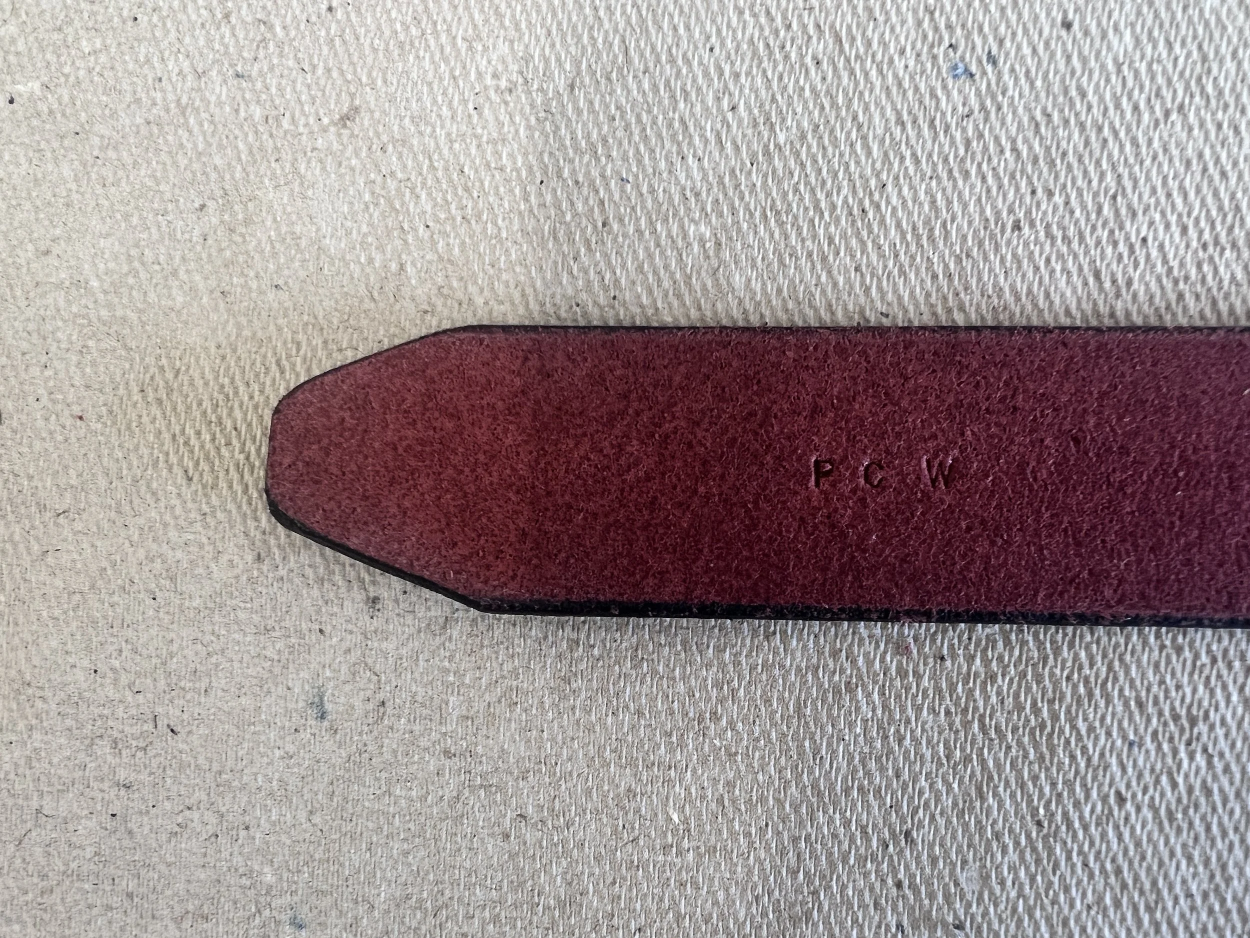 end of belt with initials stamped on the inside