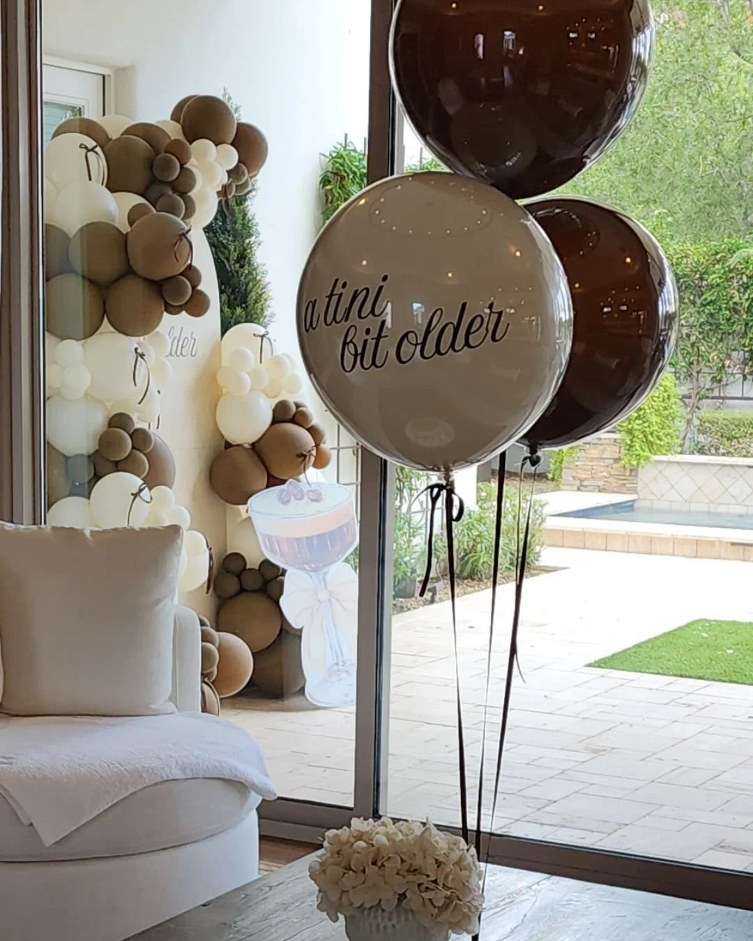 a tini bit older birthday party balloon garland and backdrop