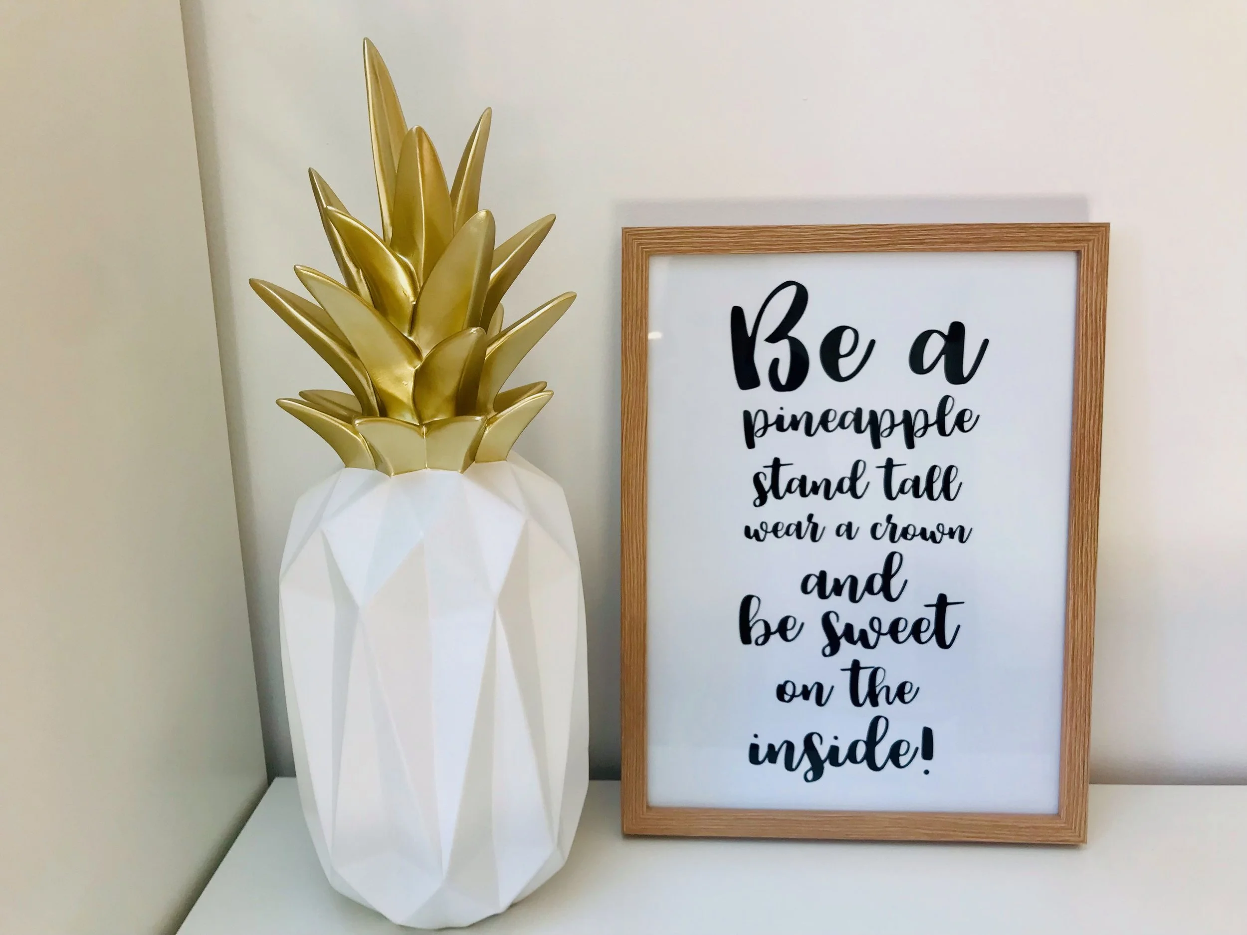 Dekoananas und motivierender Spruch in Bilderrahmen