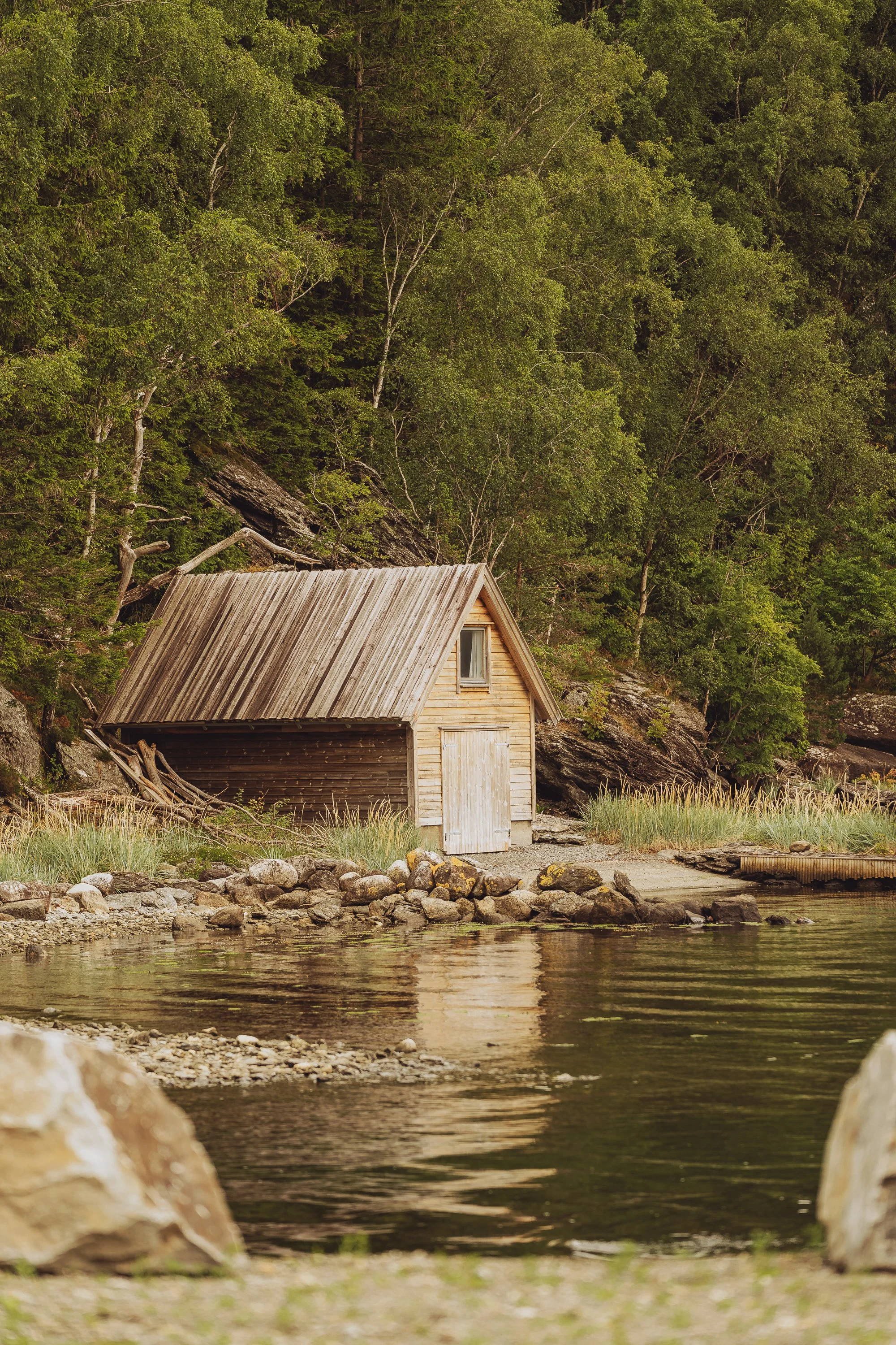 Lite naust ved sjøen utenfor Sterling Halibut sitt anlegg på Imsland.