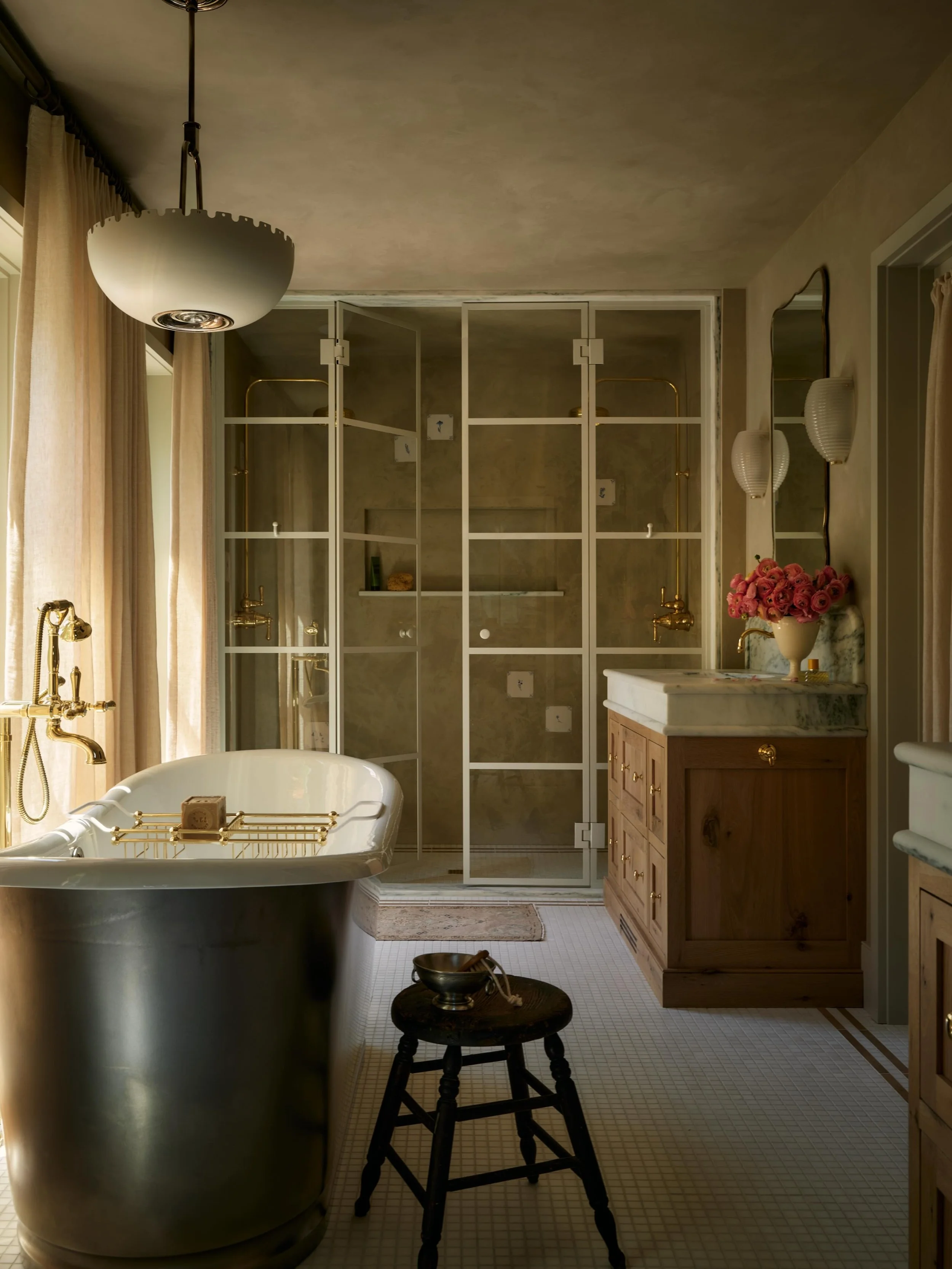 Step into the Primary Bath at Mysa Hus. This room really has it all: plastered walls (with handmade delft tiles set into the plaster in the shower), a tonal framed shower enclosure, white oak vanities, an abundance of natural light, custom floor tile