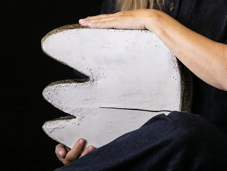 Person holding a large, white, wooden sculpture resembling Pac-Man.
