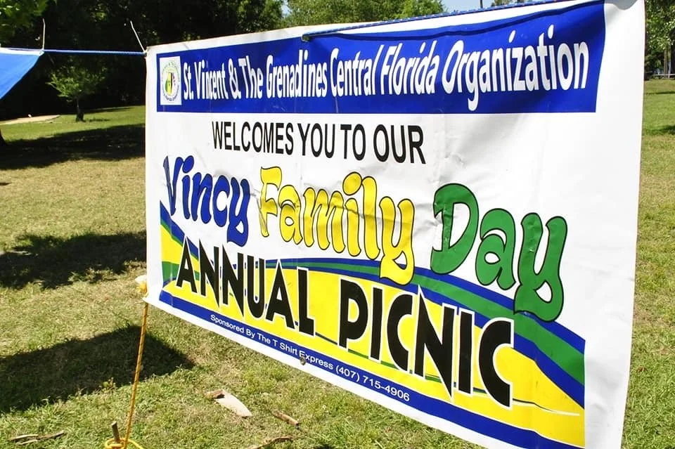 Sign for St. Vincent & The Grenadines Central Florida Organization inviting families to an annual family day picnic, promoted by T Shirt Express.