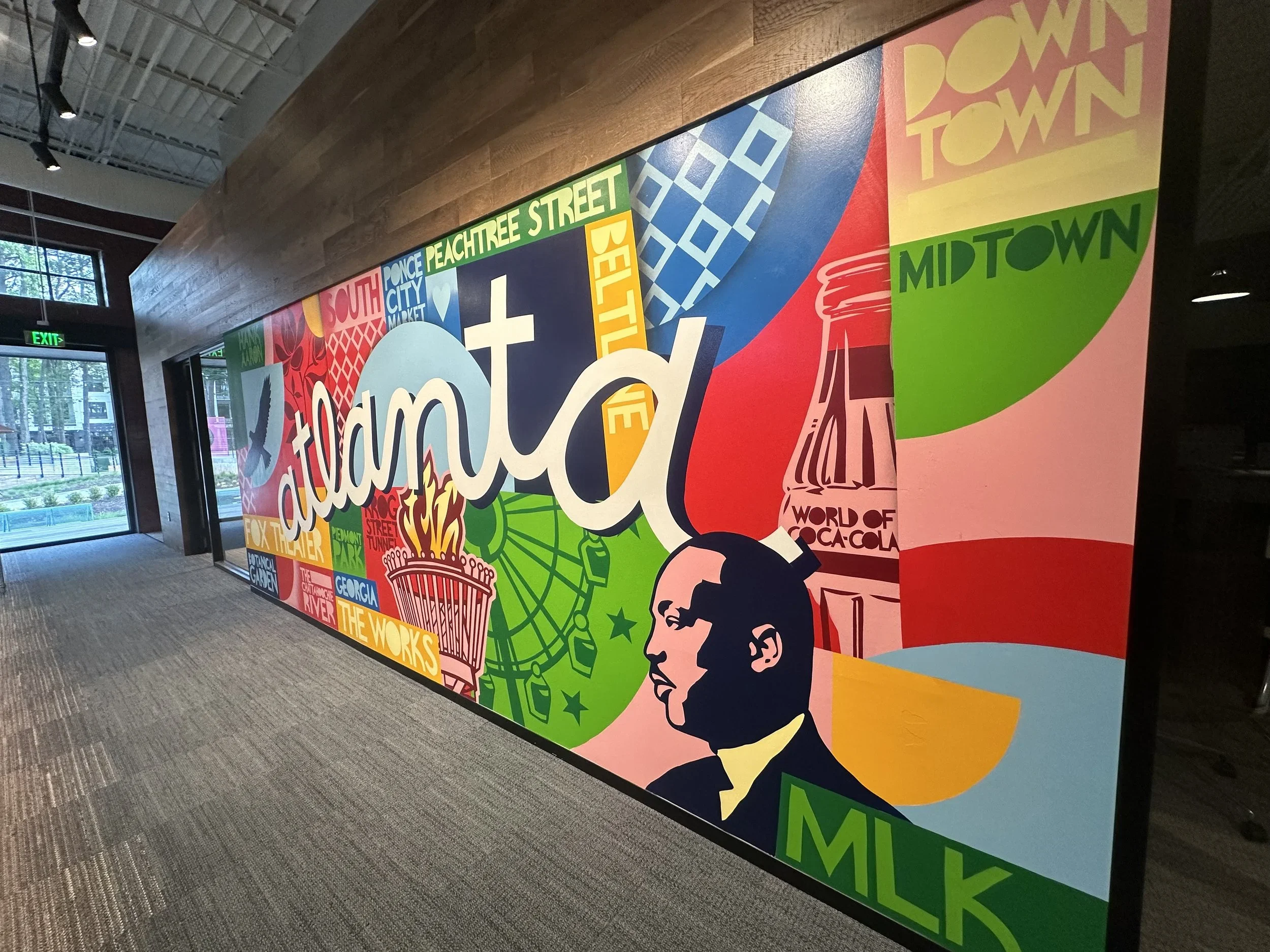 Office view of Google Fiber mural by John Tindel showcasing Atlanta's history.