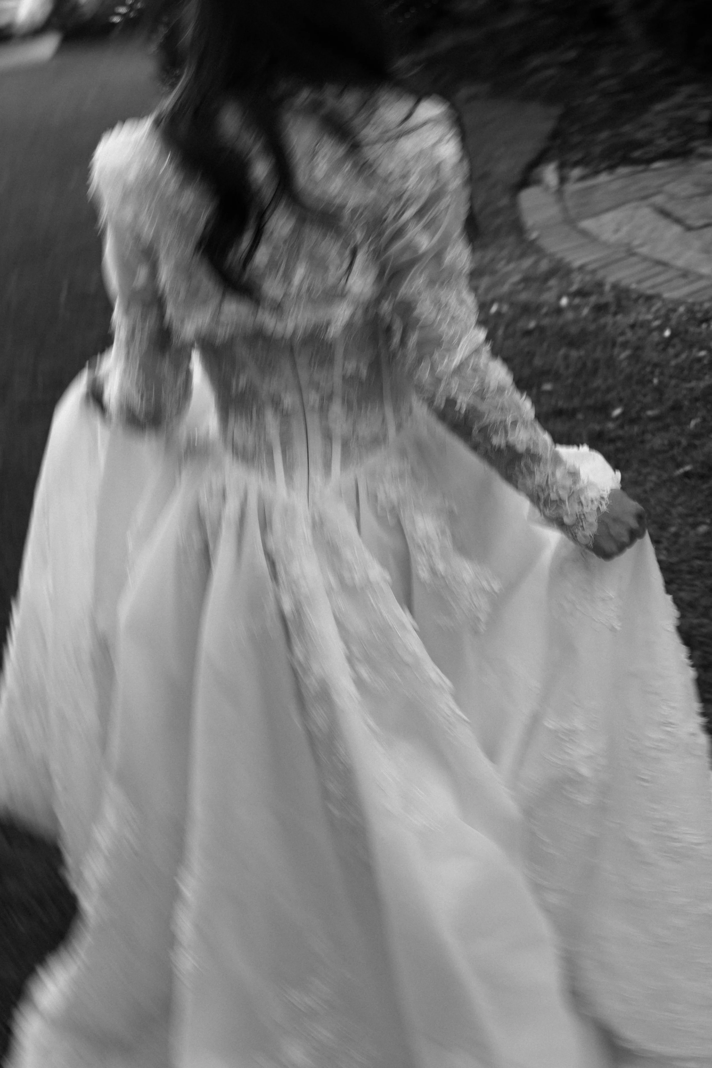 A montion blurred photos of a woman in a wedding dress holding the skirt of her gown, running walking outdoors 