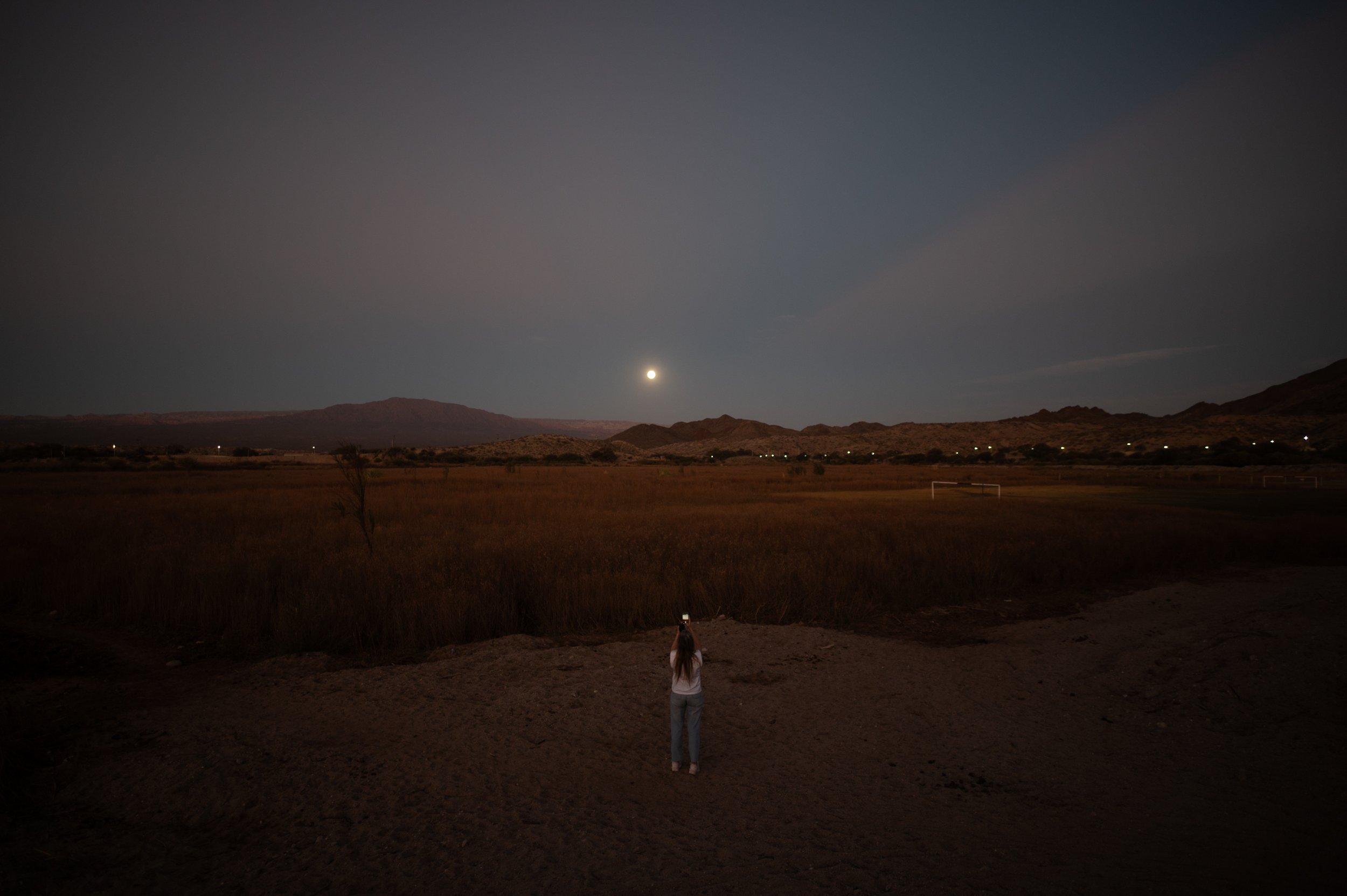 Una mujer toma fotografías de la luna llena en la localidad de Molinos, Salta, el jueves 27 de agosto del 2026. Fotografía de Mario De Fina.