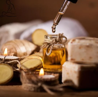 A dropper above a small jar of oil, with slices of ginger and blocks of cheese nearby, on a wooden surface.