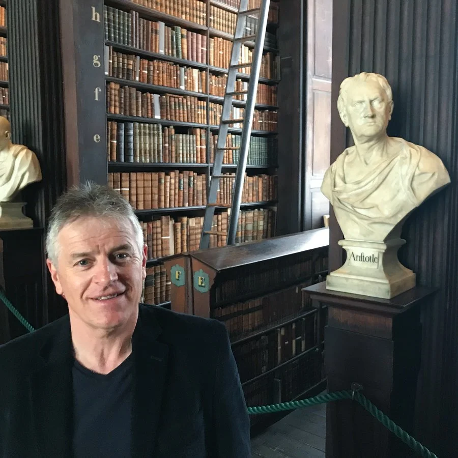 Bob standing in front of a bust of Aristotle