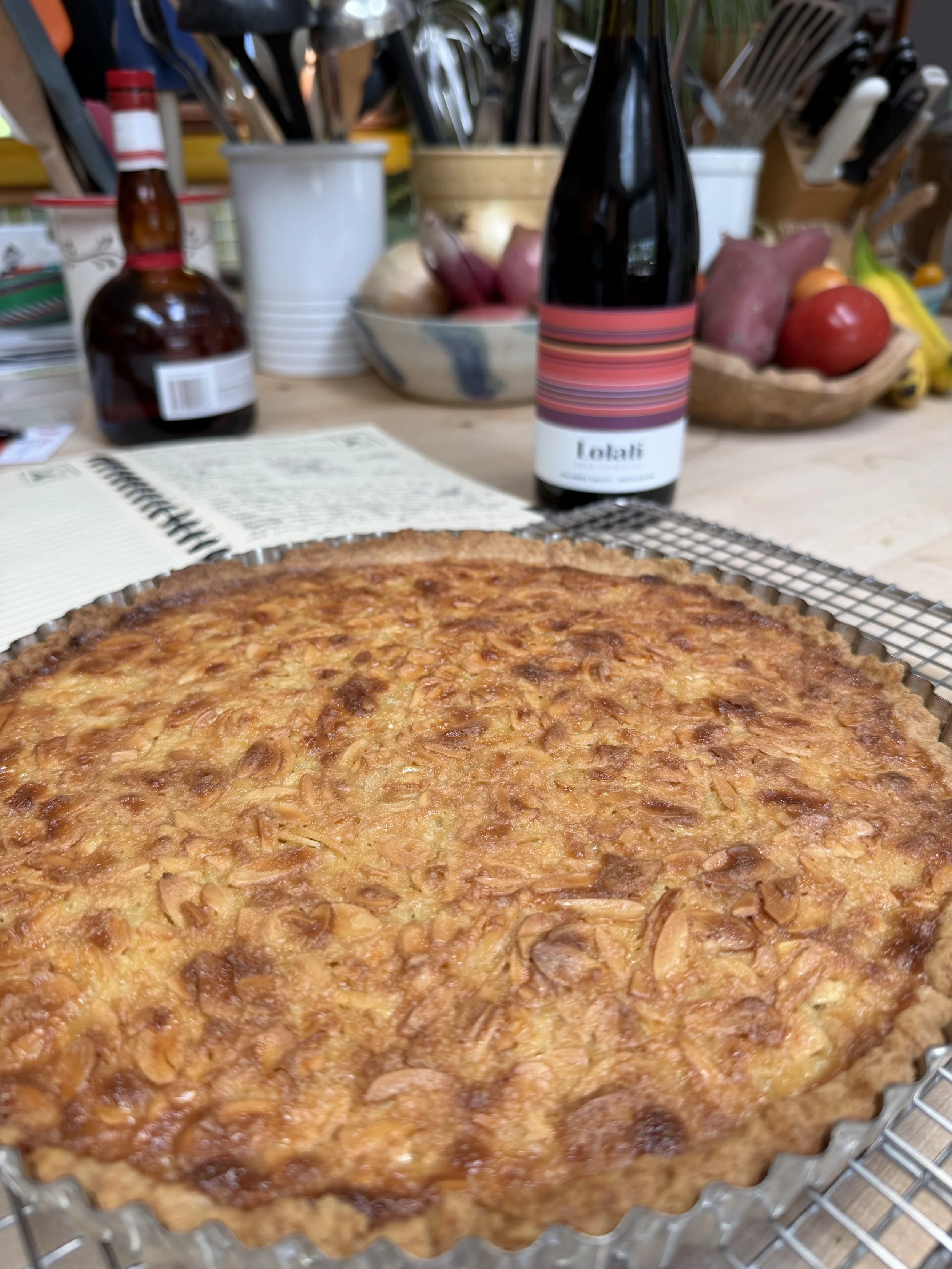Almond tart dessert with a bottle of Lolati Primitivo in the background.