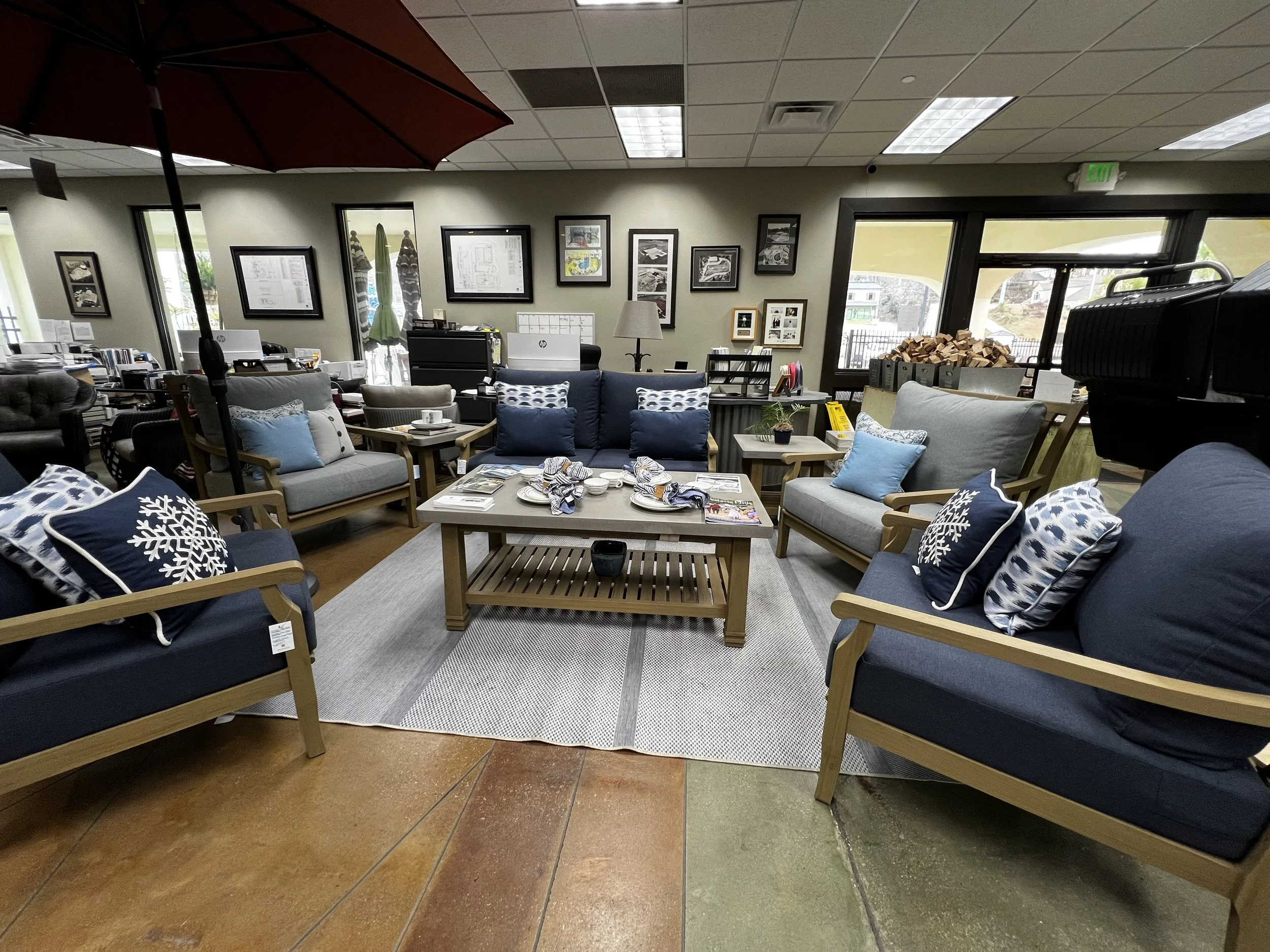Six piece, grey and navy outdoor furniture set in a circle in Hollywood Outdoor Living's store
