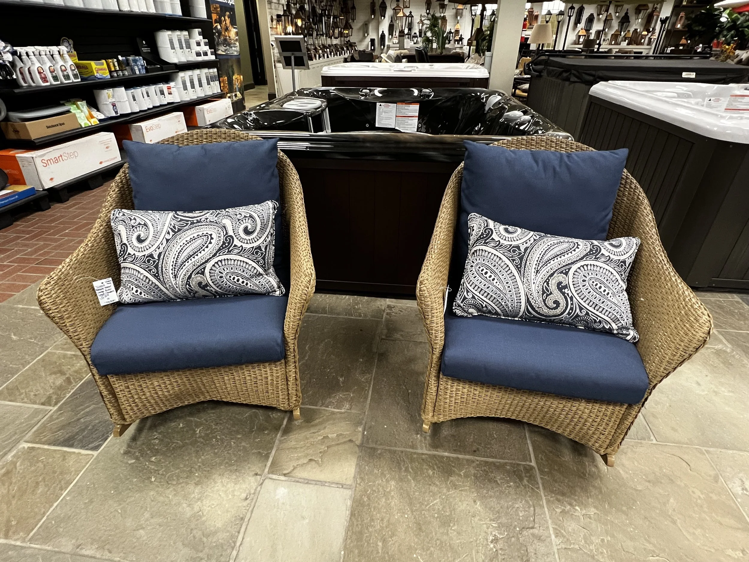 Two tan wicker chairs with navy cusions in Hollywood Outdoor Living's store
