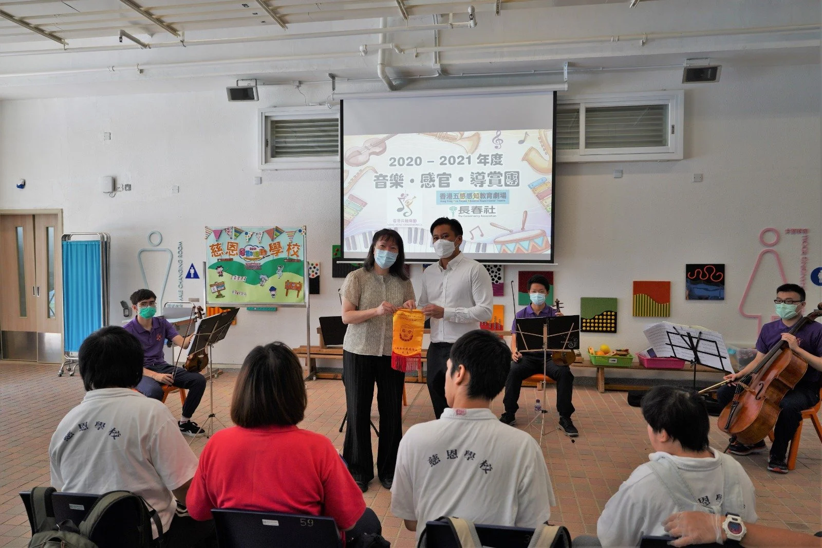 The school presenting a commemorative pennant to Hong Kong Enharmonica