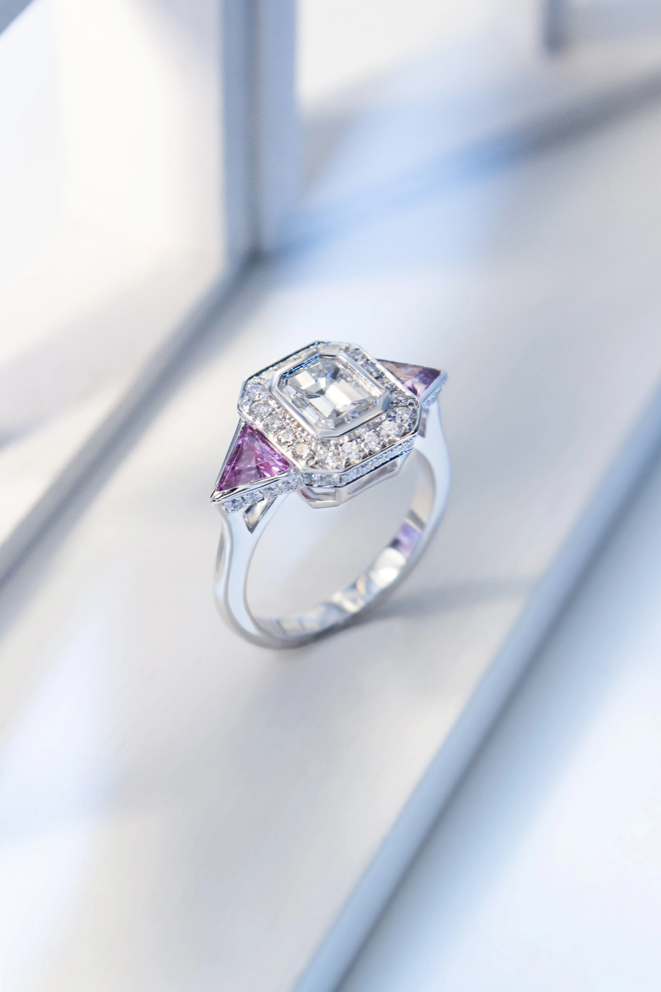 Platinum with diamond and pink sapphires in a halo trilogy design by Sophie Cudworth